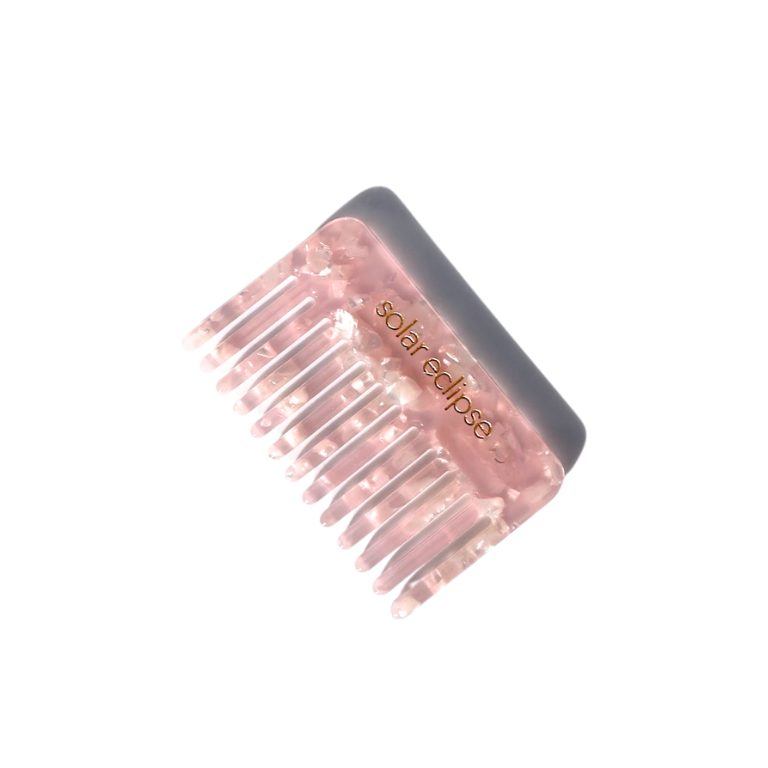 Pink hair comb with 'solar eclipse' text on a white background