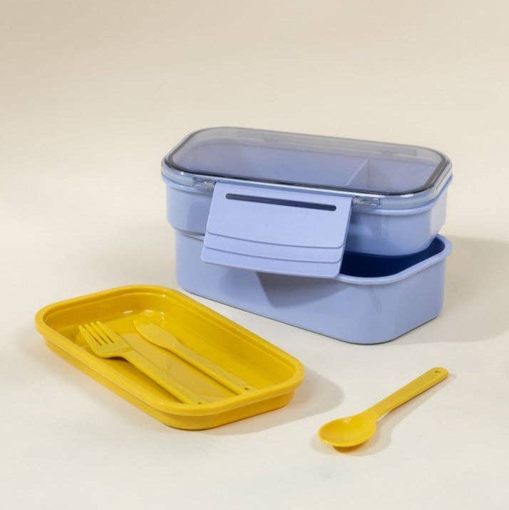Blue lunch box with yellow lid and spoon on a beige background