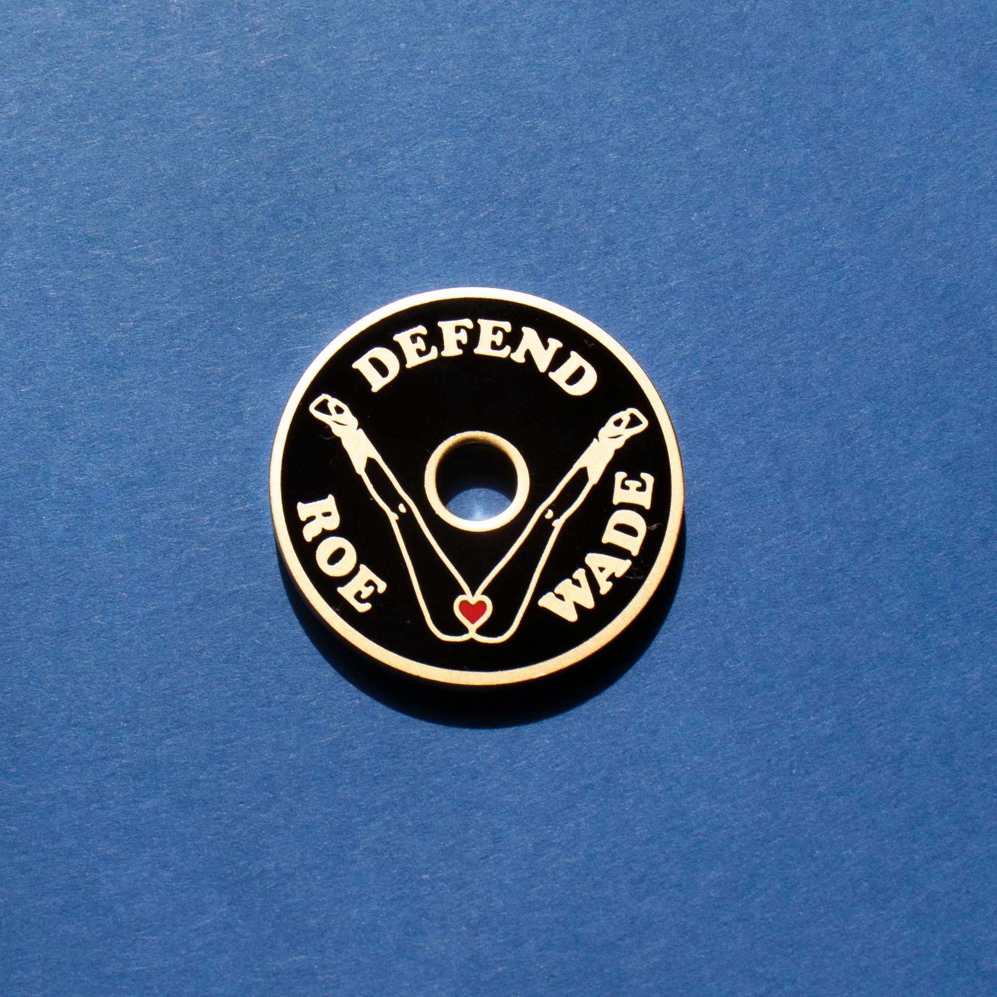 Circular badge with 'Defend Roe Wade' text on a blue background