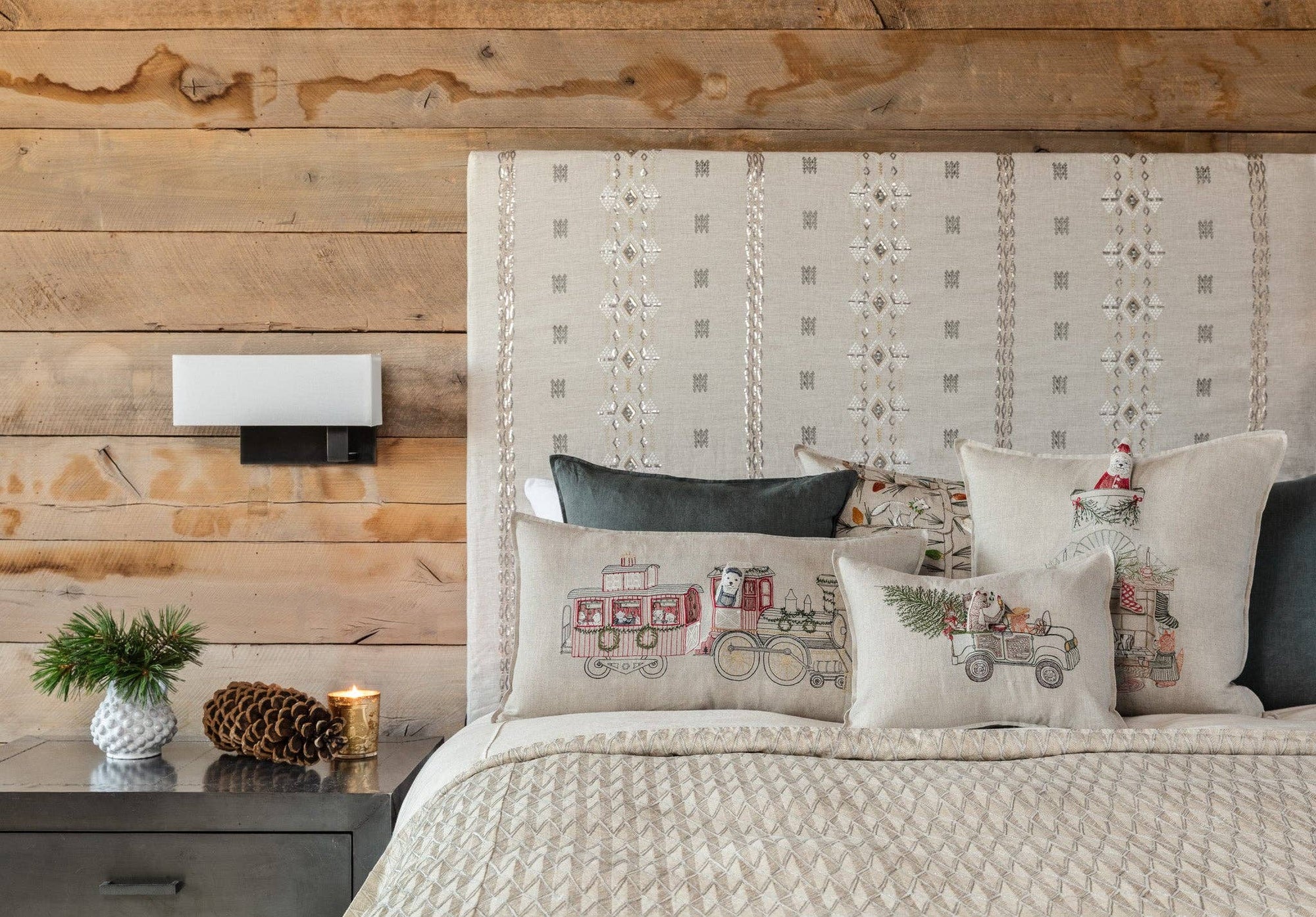 Bedroom with wooden wall, patterned headboard, and decorative pillows.