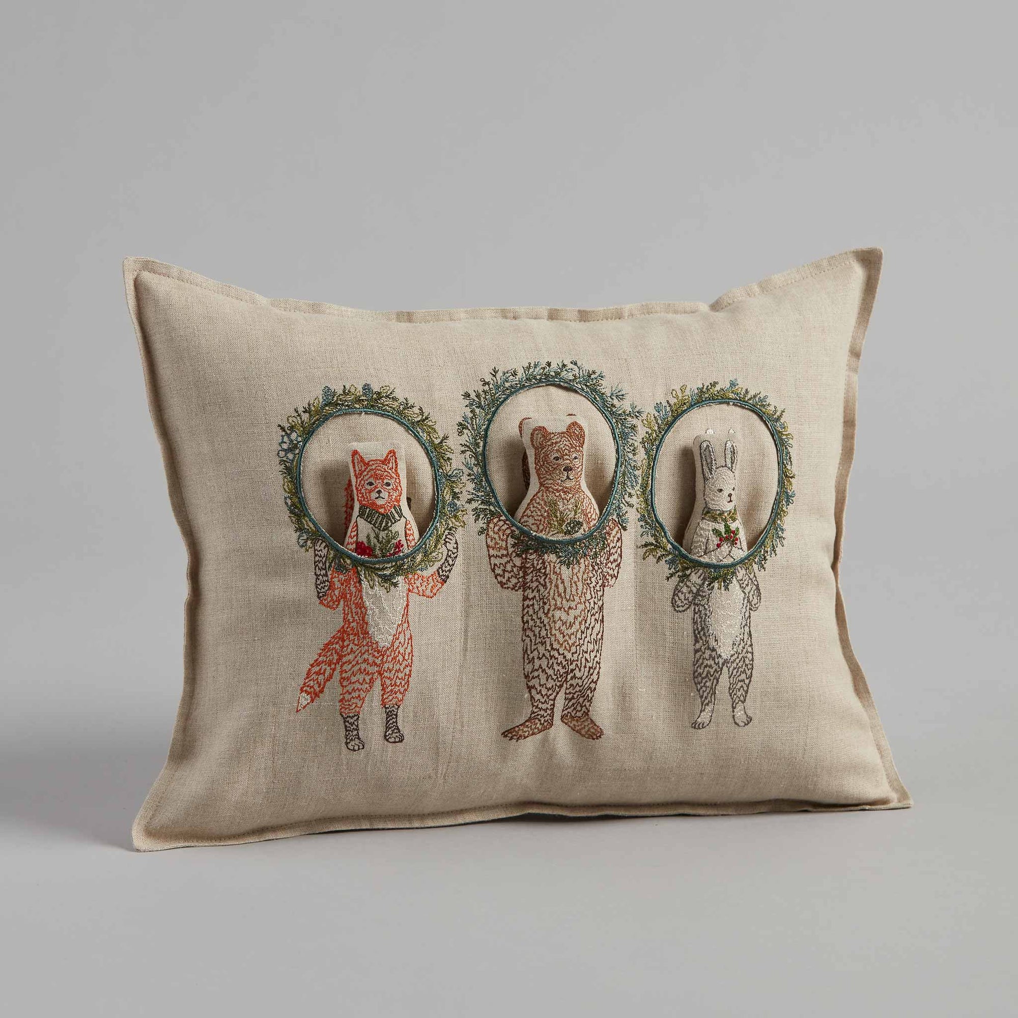 Decorative pillow with embroidered animals in wreaths on a beige background