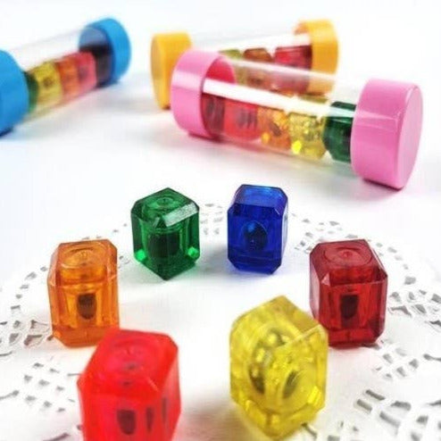 Colorful plastic dice and transparent tubes on a white surface