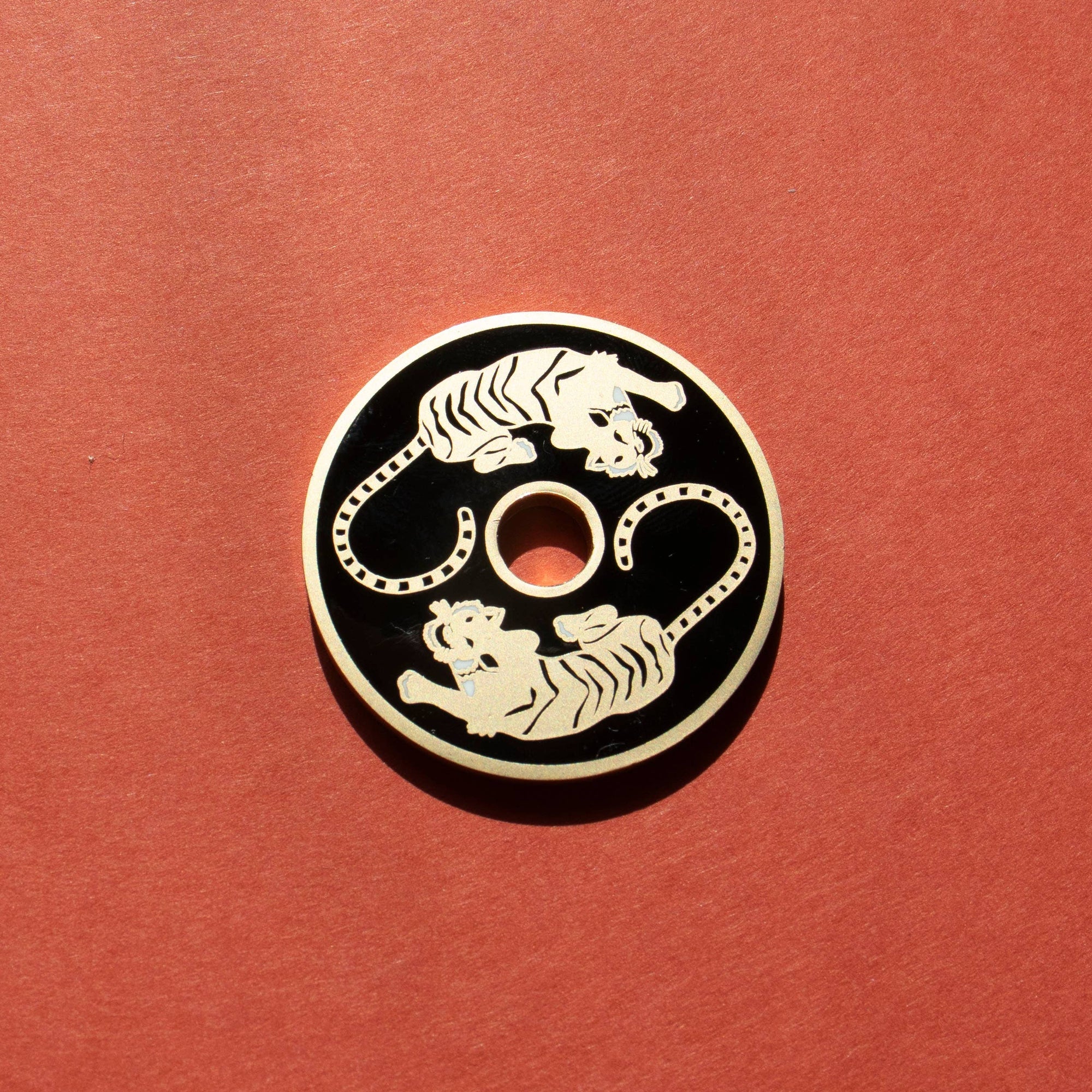 Decorative button with two tigers on a red background