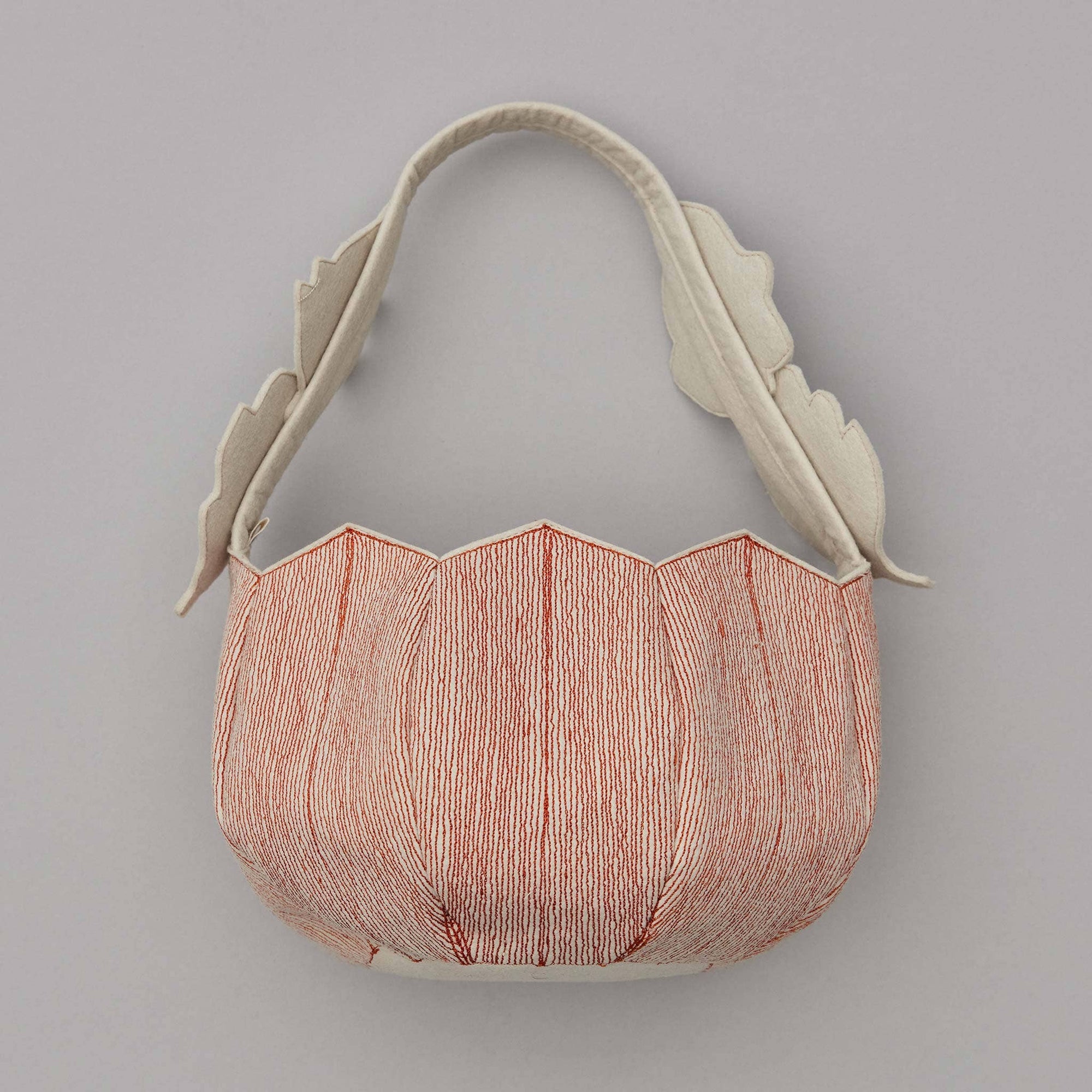 Decorative ceramic wall piece with leaf-like handles on a gray background