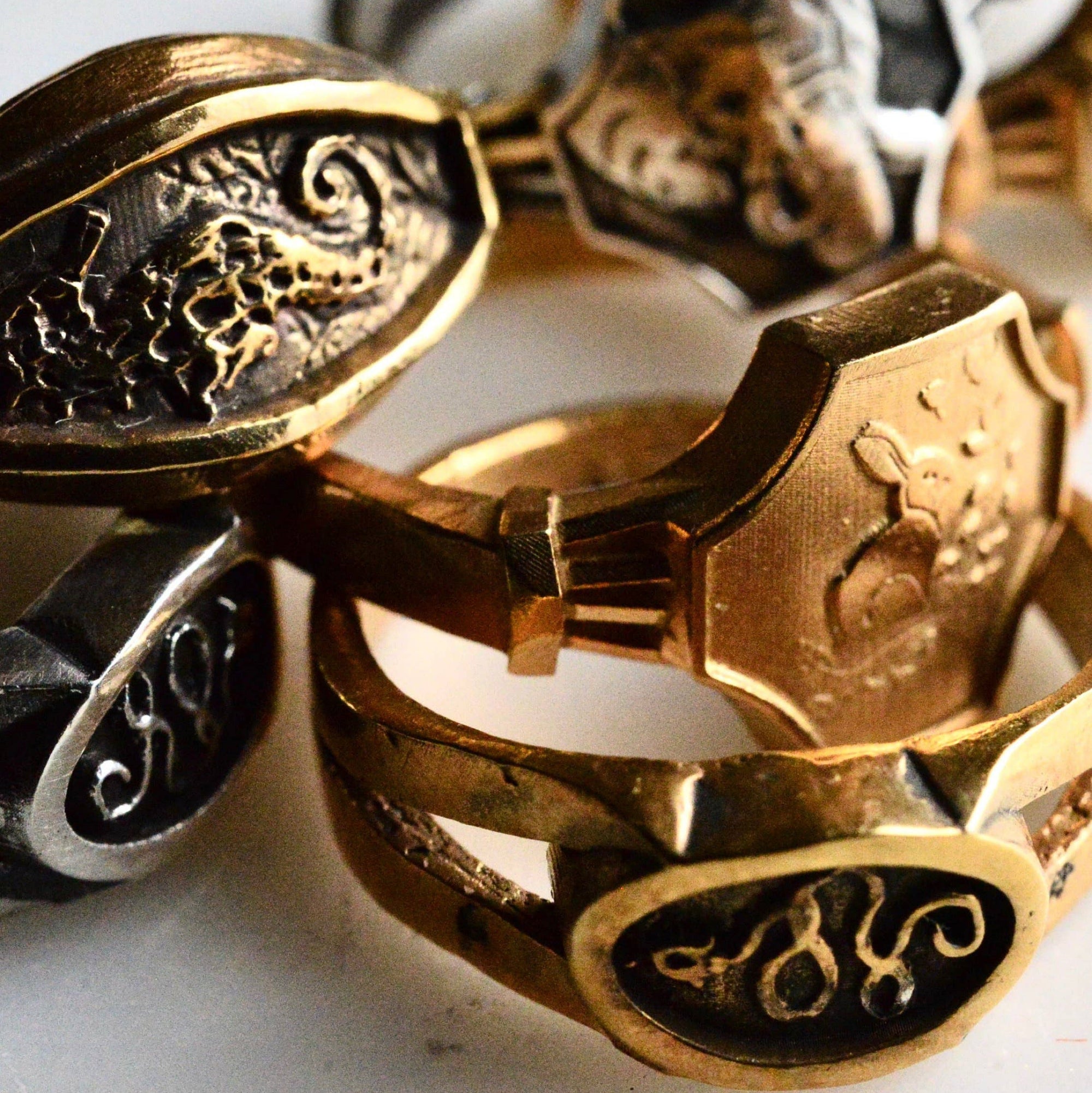 Close-up of gold and silver rings with engraved designs on a white background
