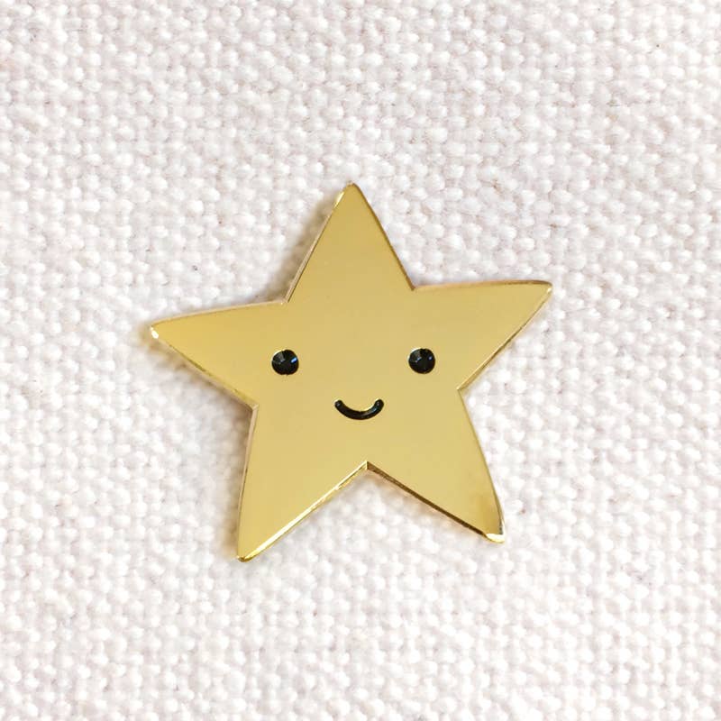 Gold star-shaped pin with a smiley face on a white background