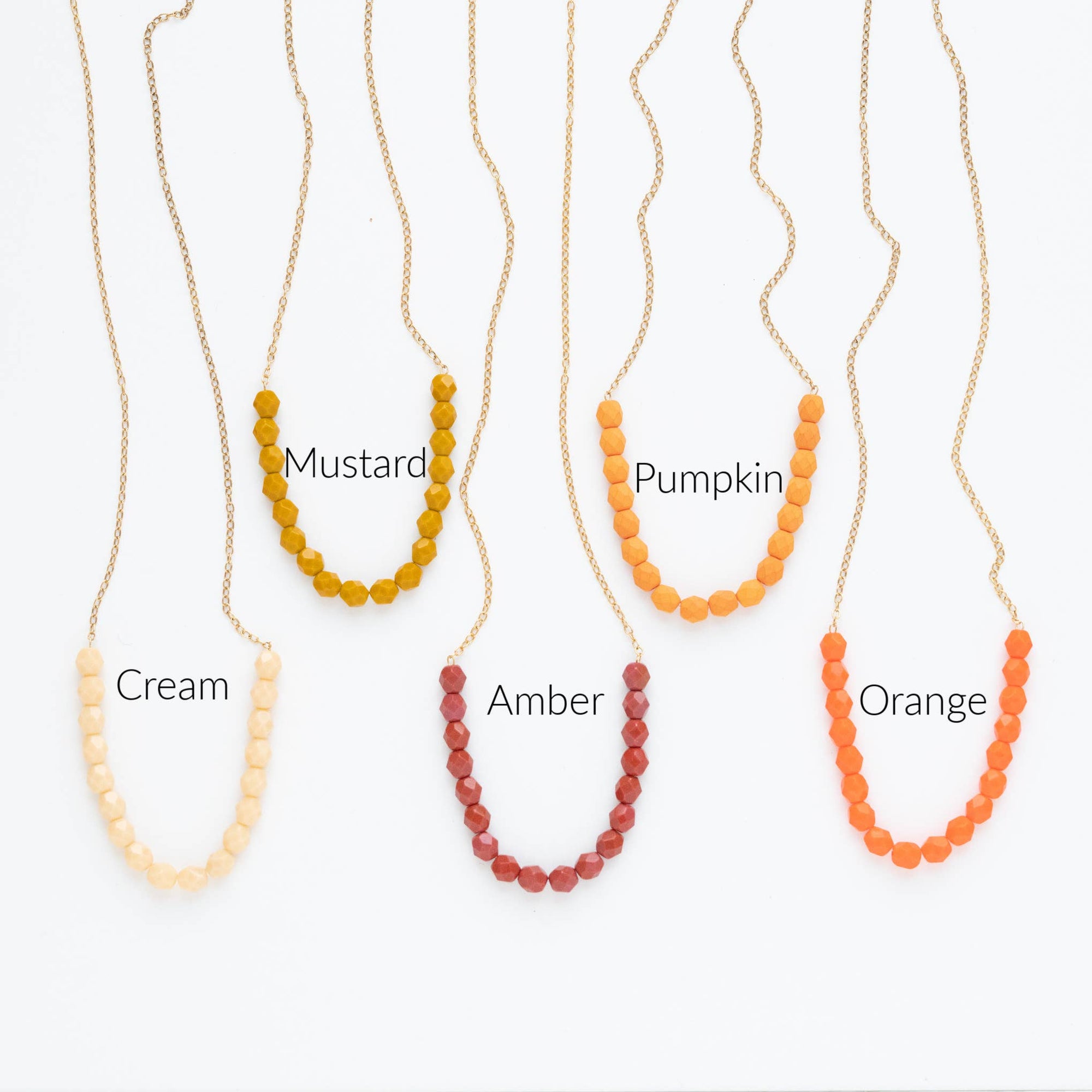 Set of five beaded necklaces in different colors with labels on a white background