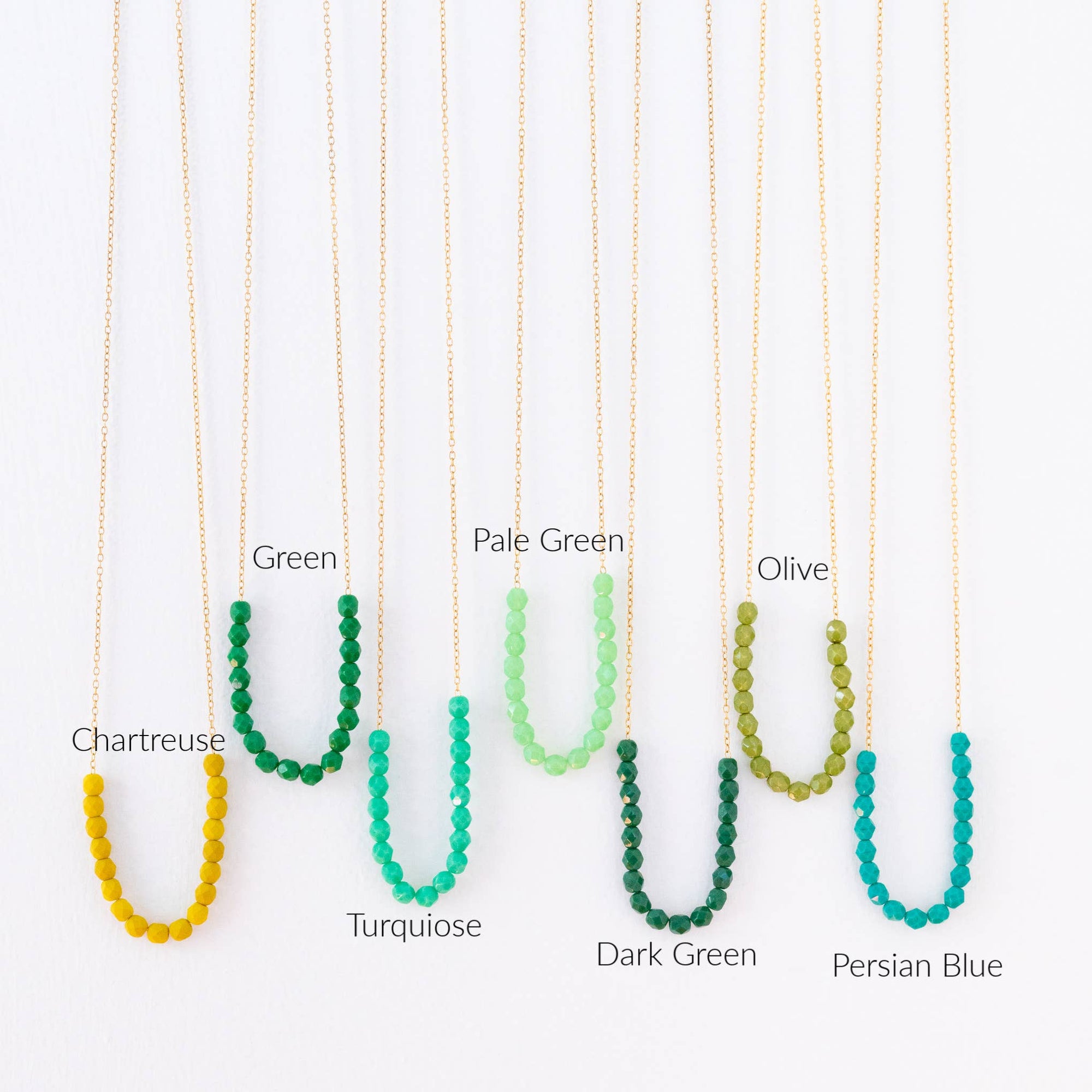 Set of beaded necklaces in various colors on a white background