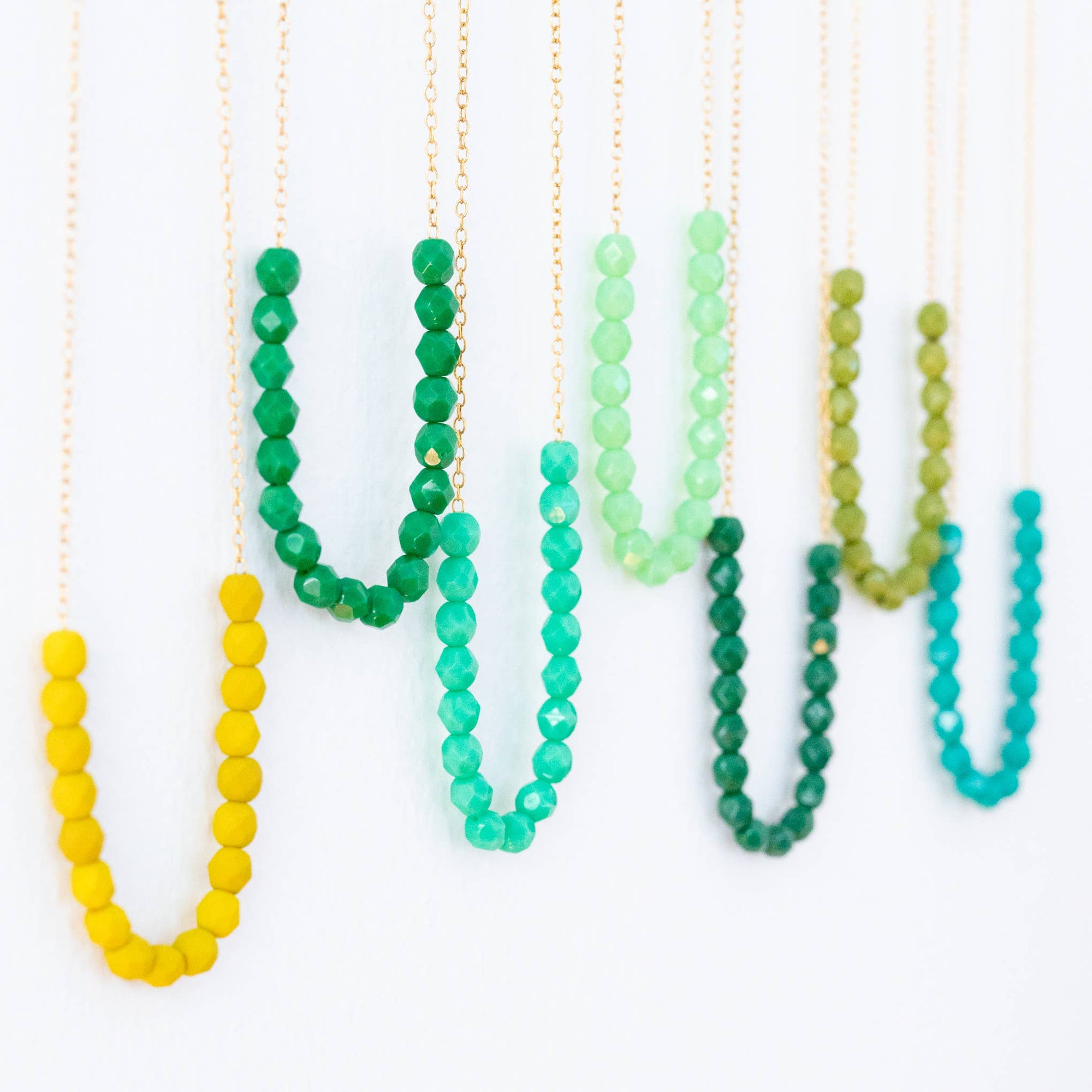 Set of colorful beaded necklaces on a white background