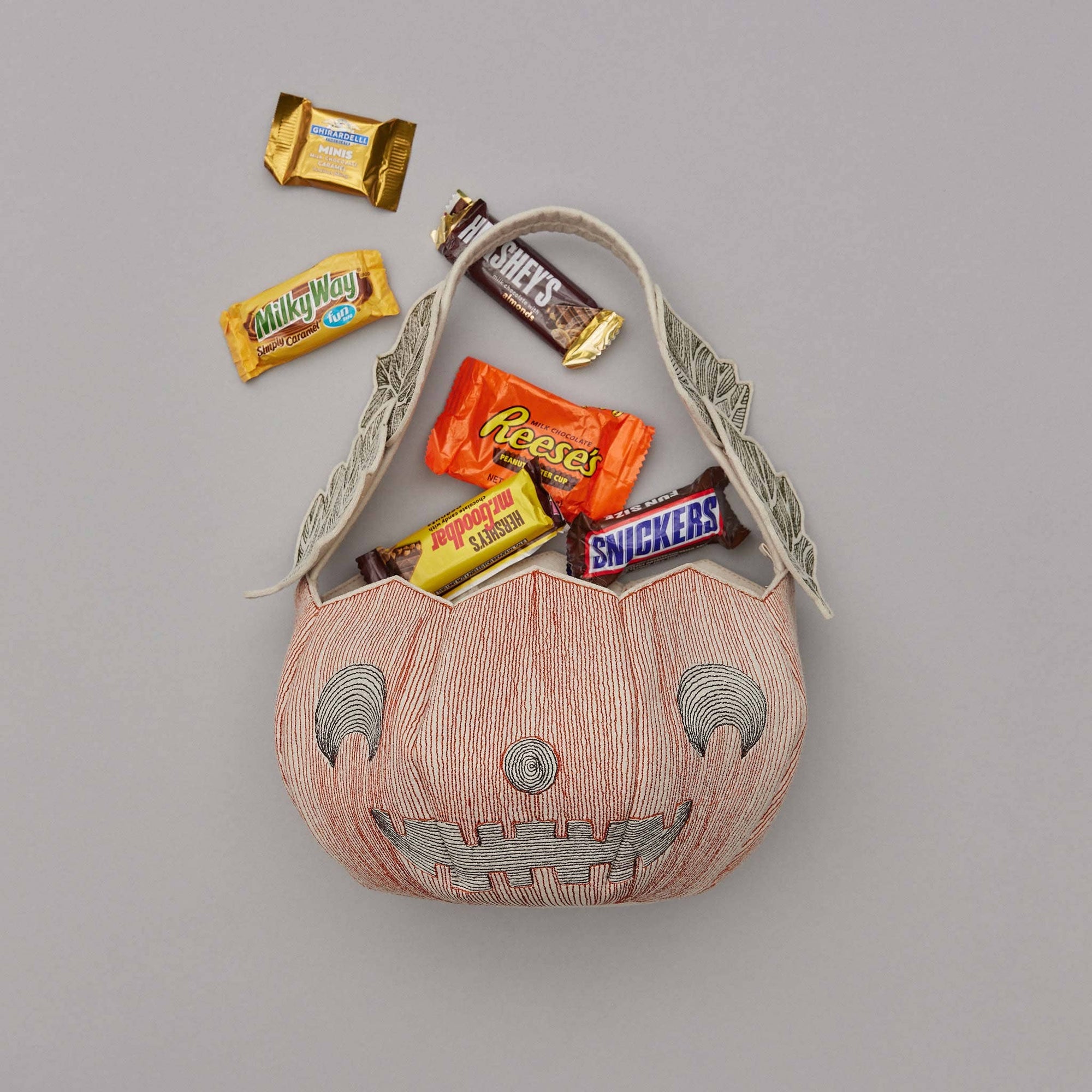 Halloween candy bag with candy bars on a gray background