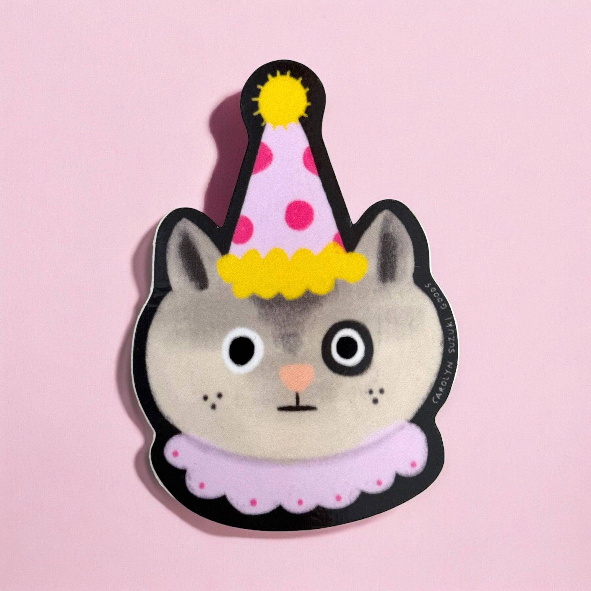 Cat-shaped sticker with a party hat on a pink background