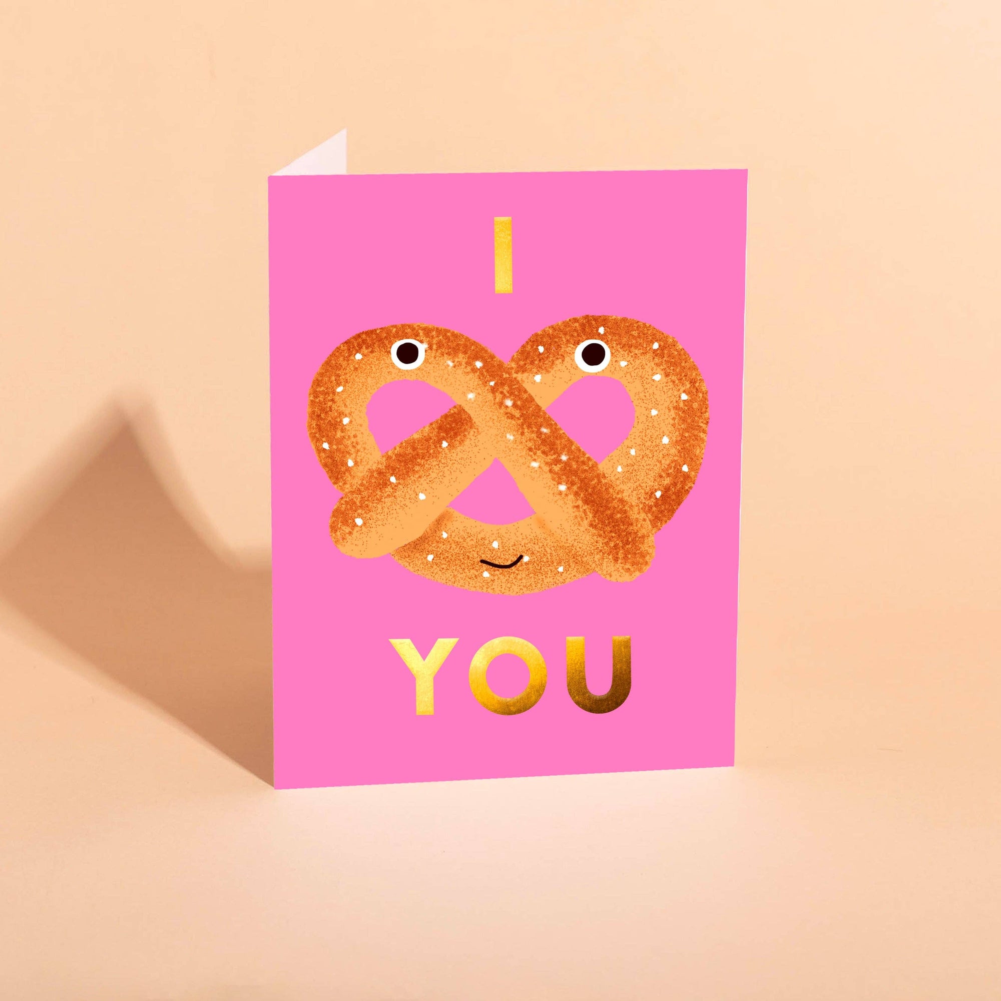 Greeting card with pretzels and 'I love you' text on a pink background