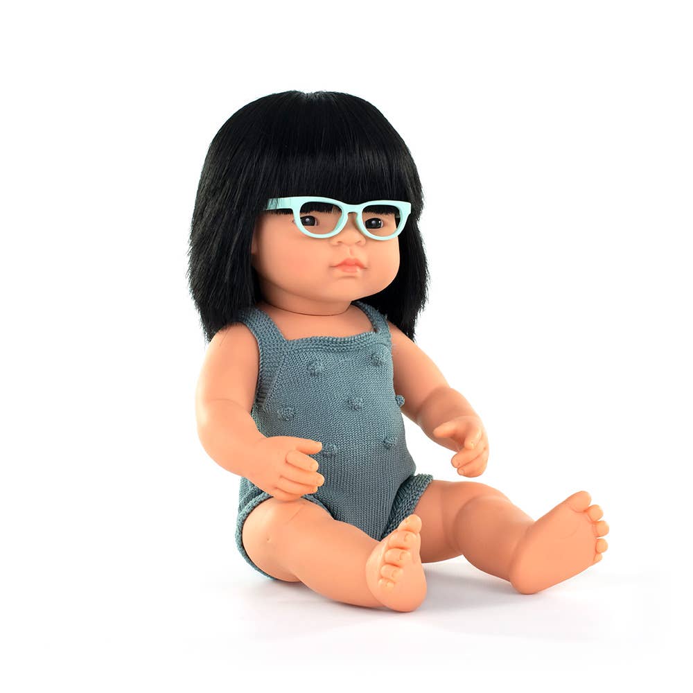 Doll with black hair and blue sunglasses wearing a gray romper on a white background