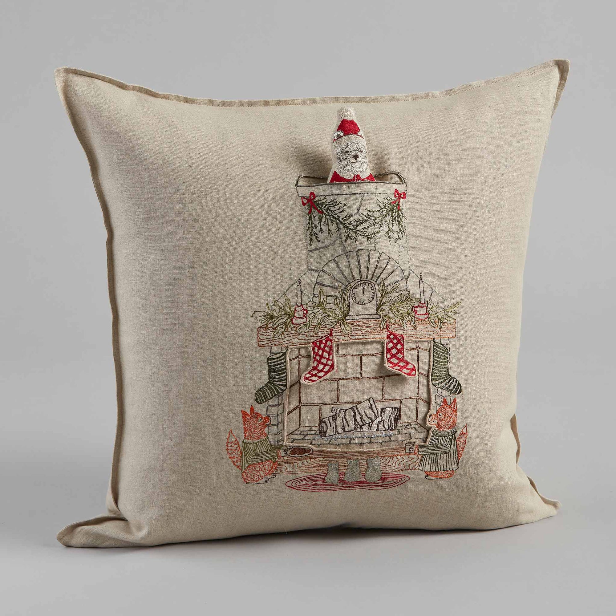 Decorative pillow with a Christmas-themed design of Santa in a chimney.