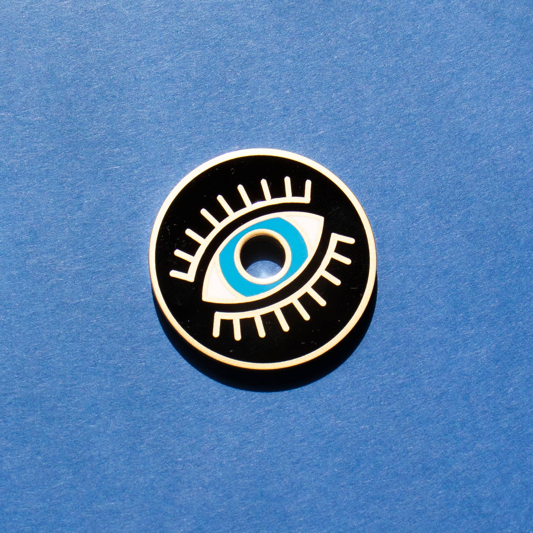 Eyeball design pin on a blue background