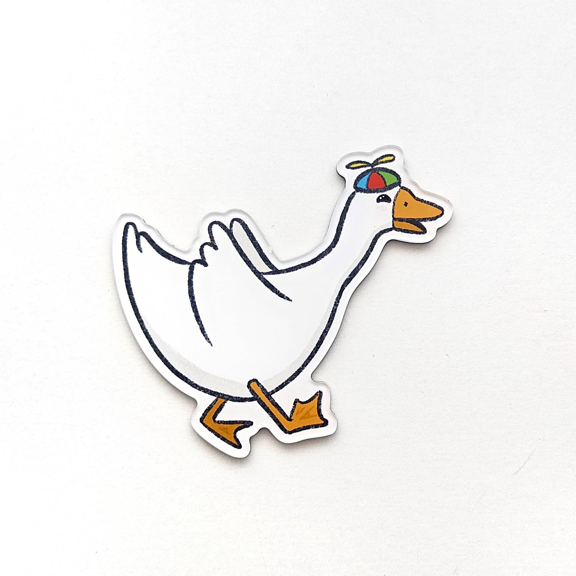 Cartoon duck magnet with colorful hat on a white background