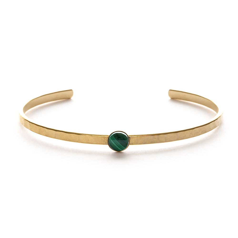 Gold bracelet with a green gemstone on a white background