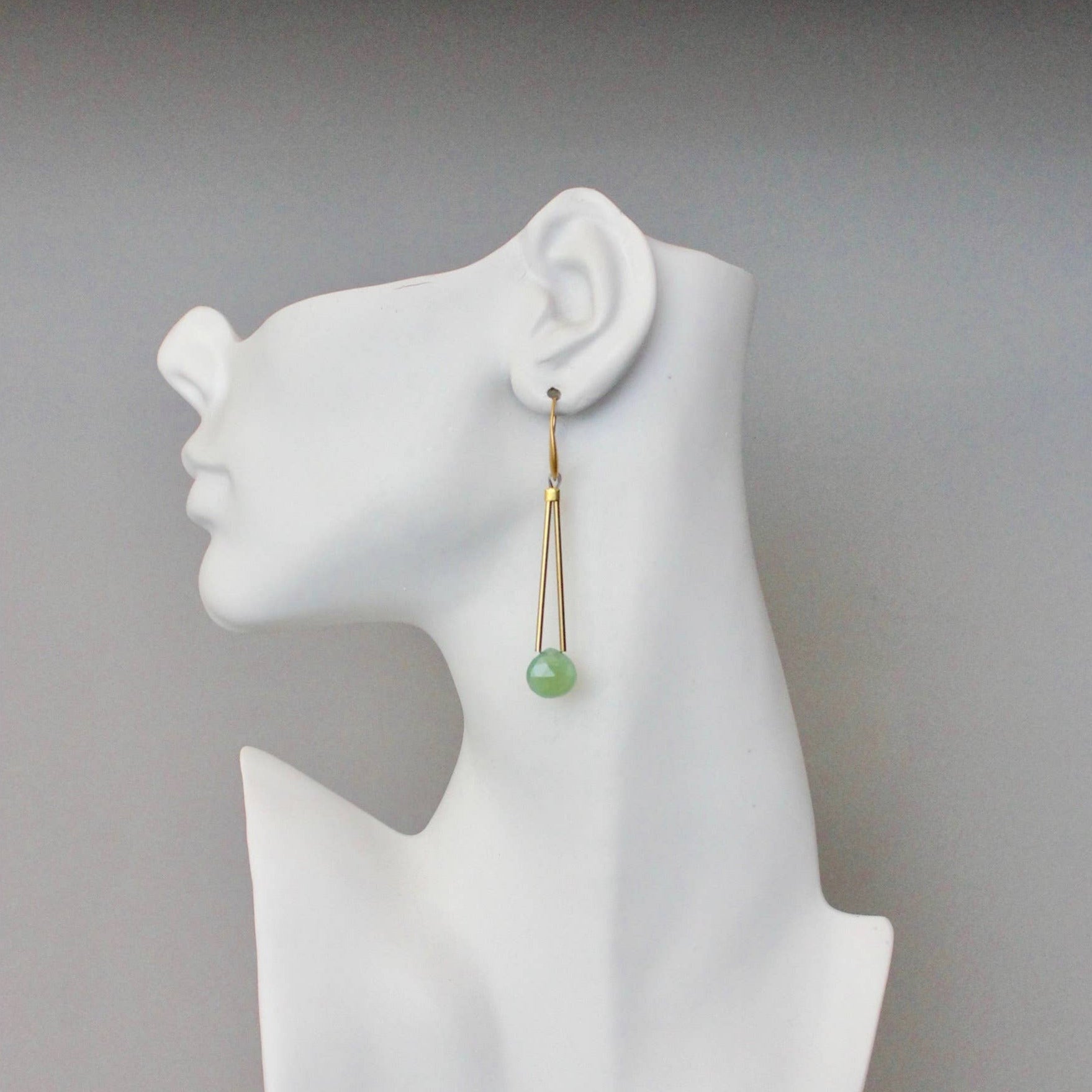 Earring on a white mannequin bust with a plain background