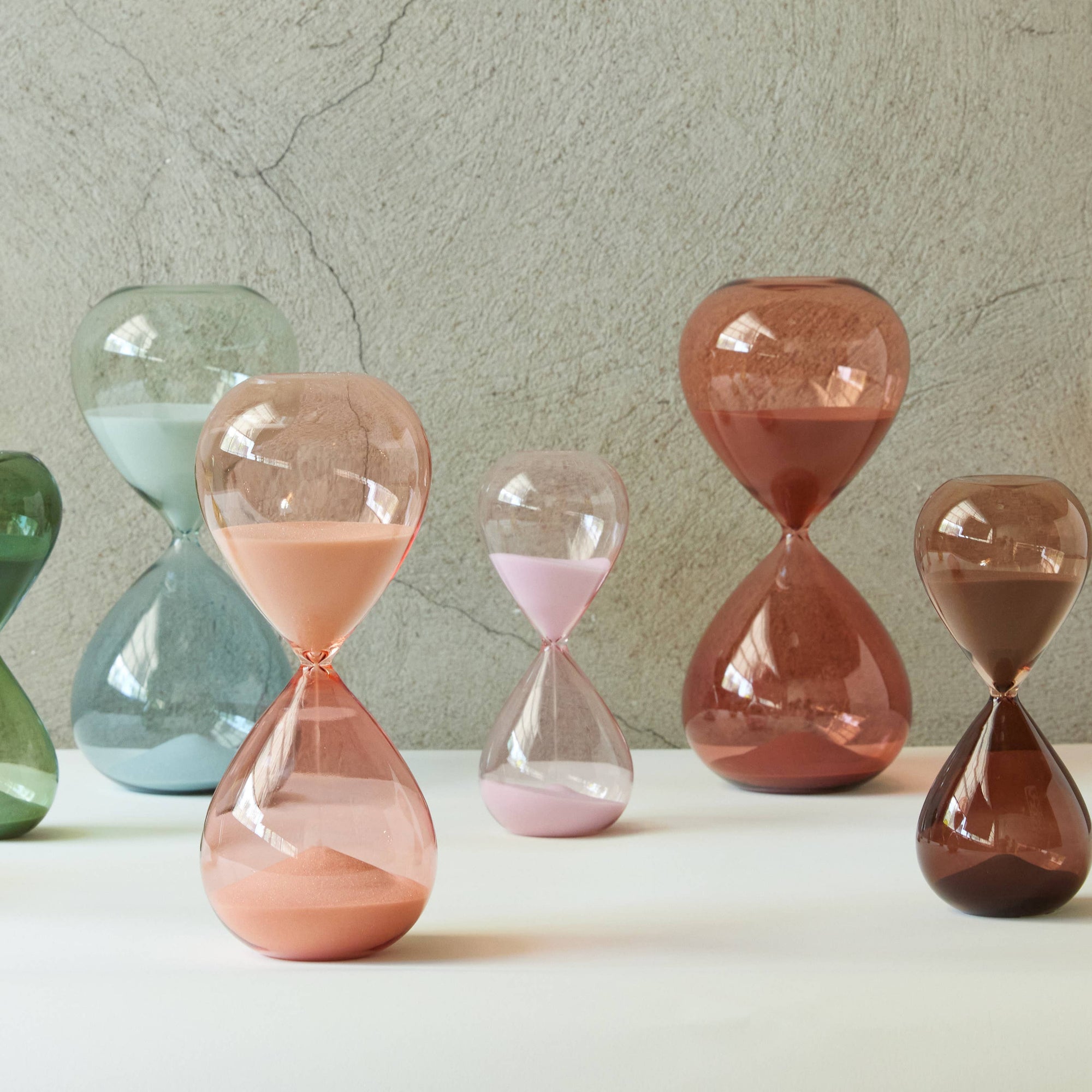 Set of colorful hourglass-shaped sand timers on a neutral background