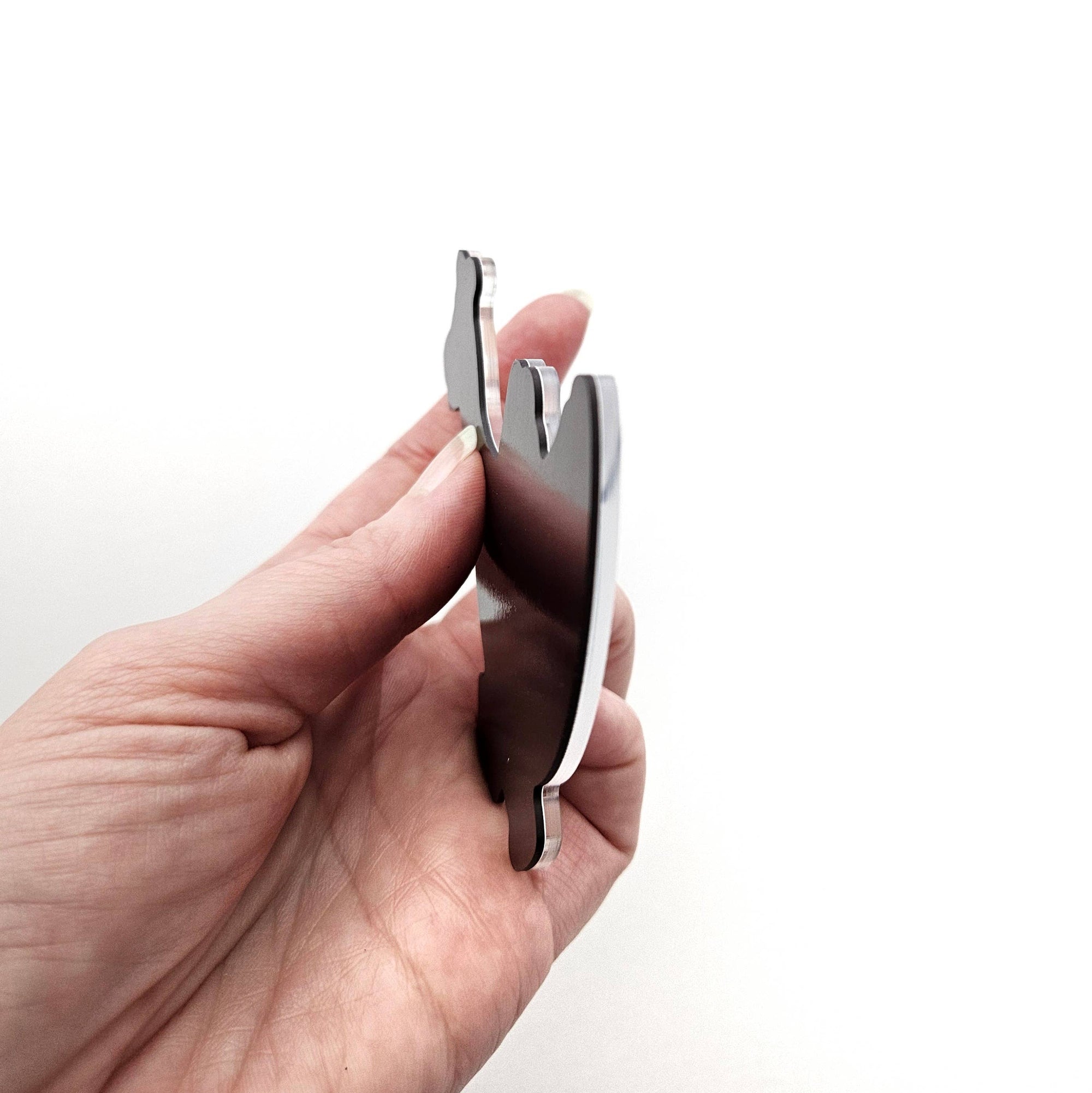 Hand holding a magnetagainst a white background