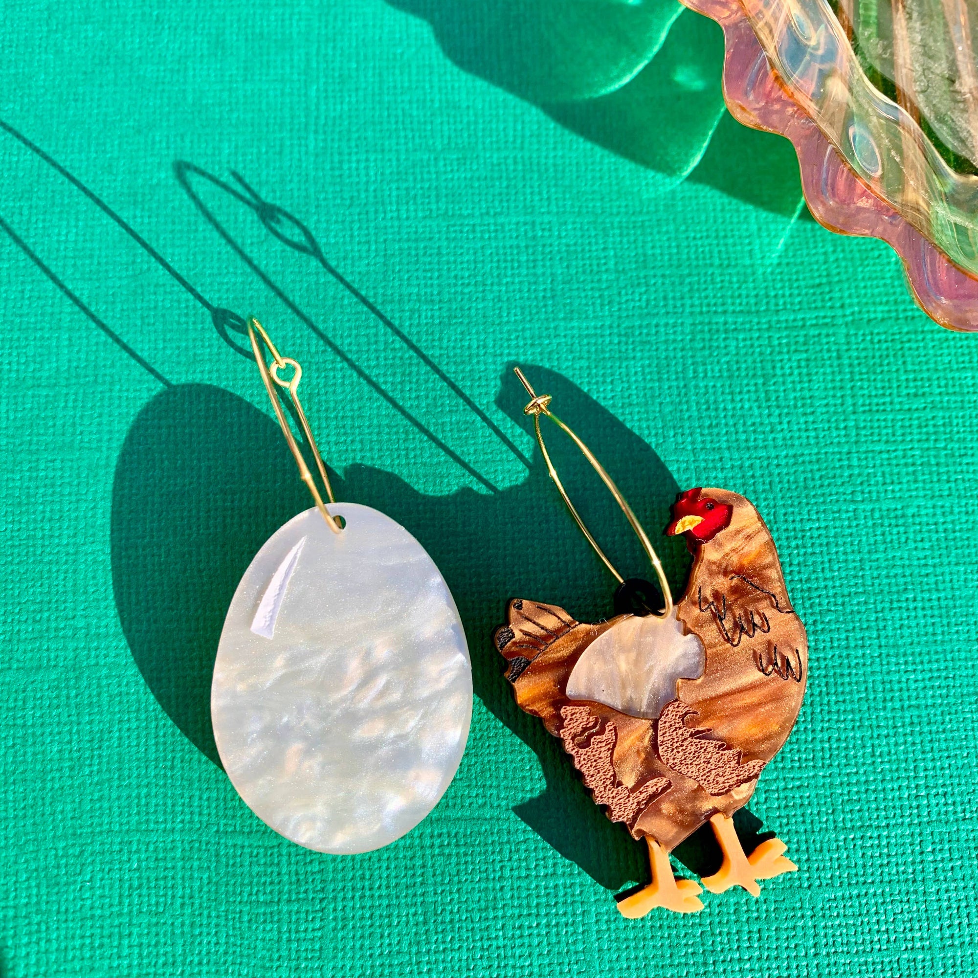 Wooden chicken ornament with a white shell-like object on a green surface