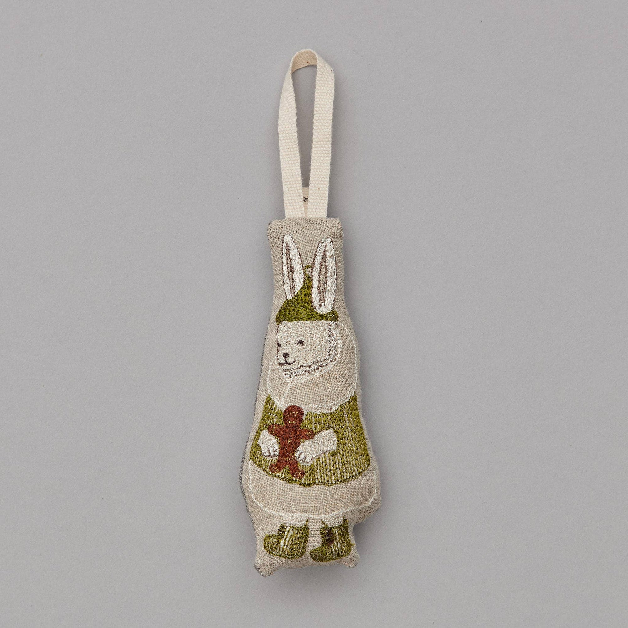 Decorative rabbit-shaped ornament with a green sweater on a gray background