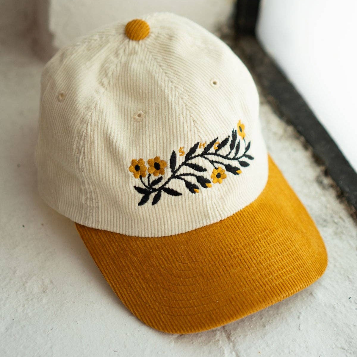 Cap with floral embroidery on a textured surface