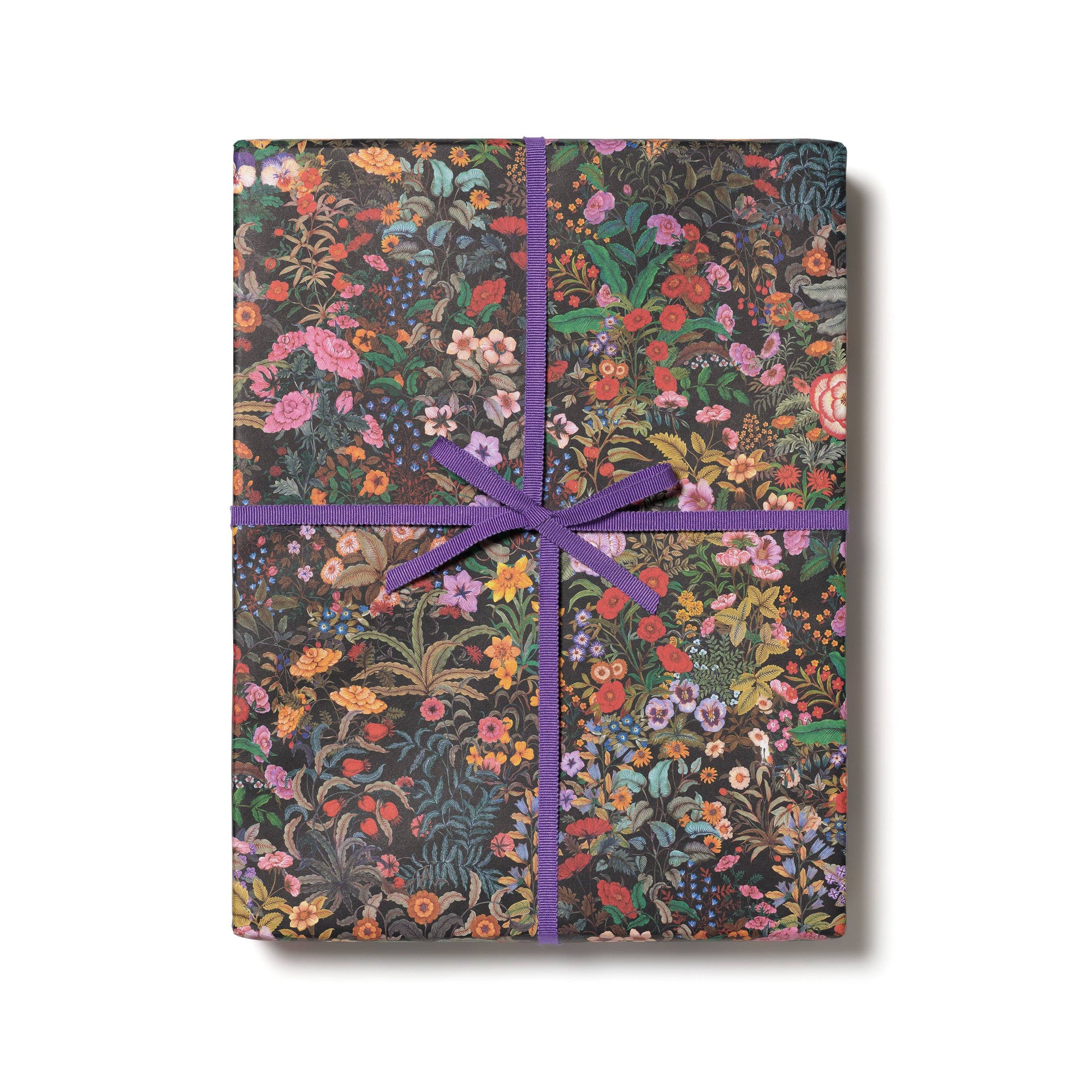 Floral-patterned gift wrap with a purple ribbon on a white background