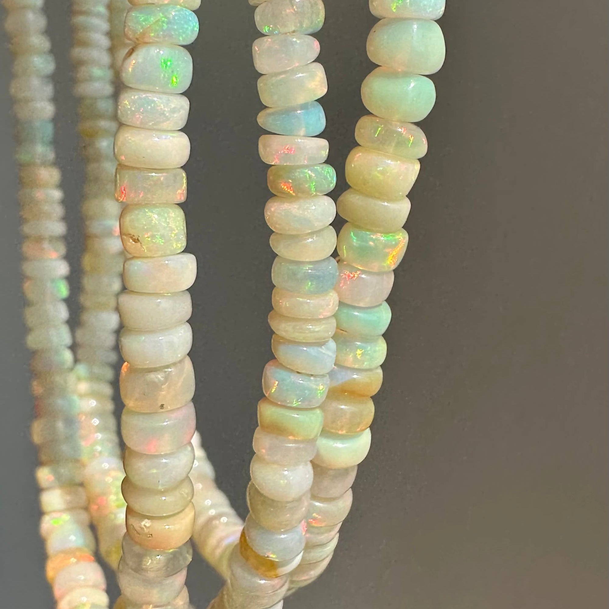 Close-up of opal beads on a gray background