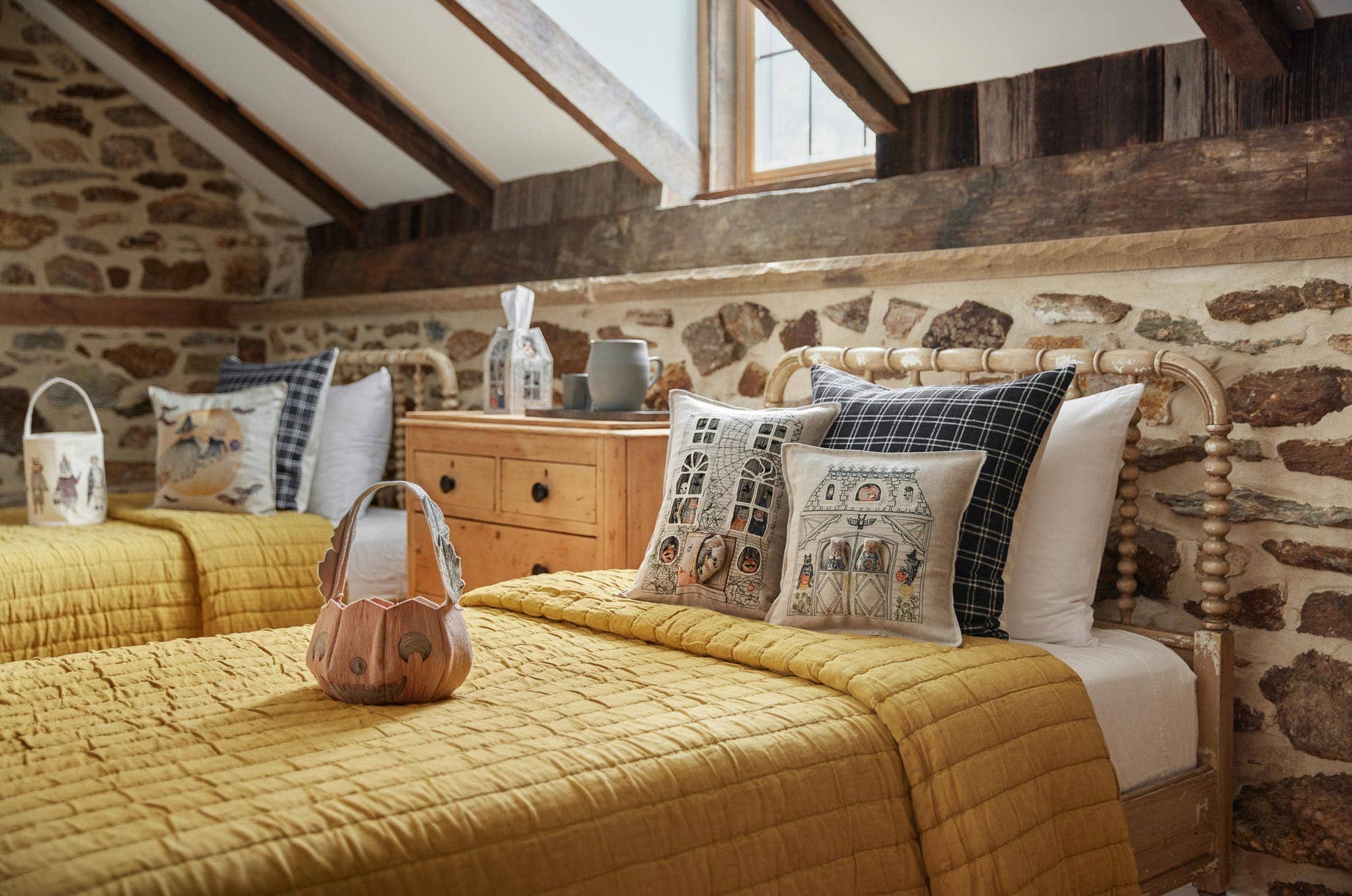 Cozy bedroom with stone walls, wooden bed, and decorative pillows.