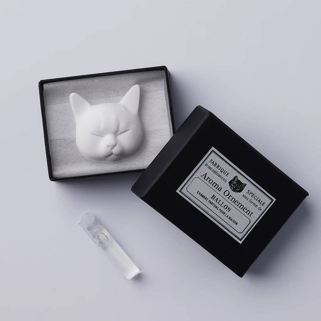 Cat-shaped soap in an open black box with a label on a light gray background and bottle of diffuser