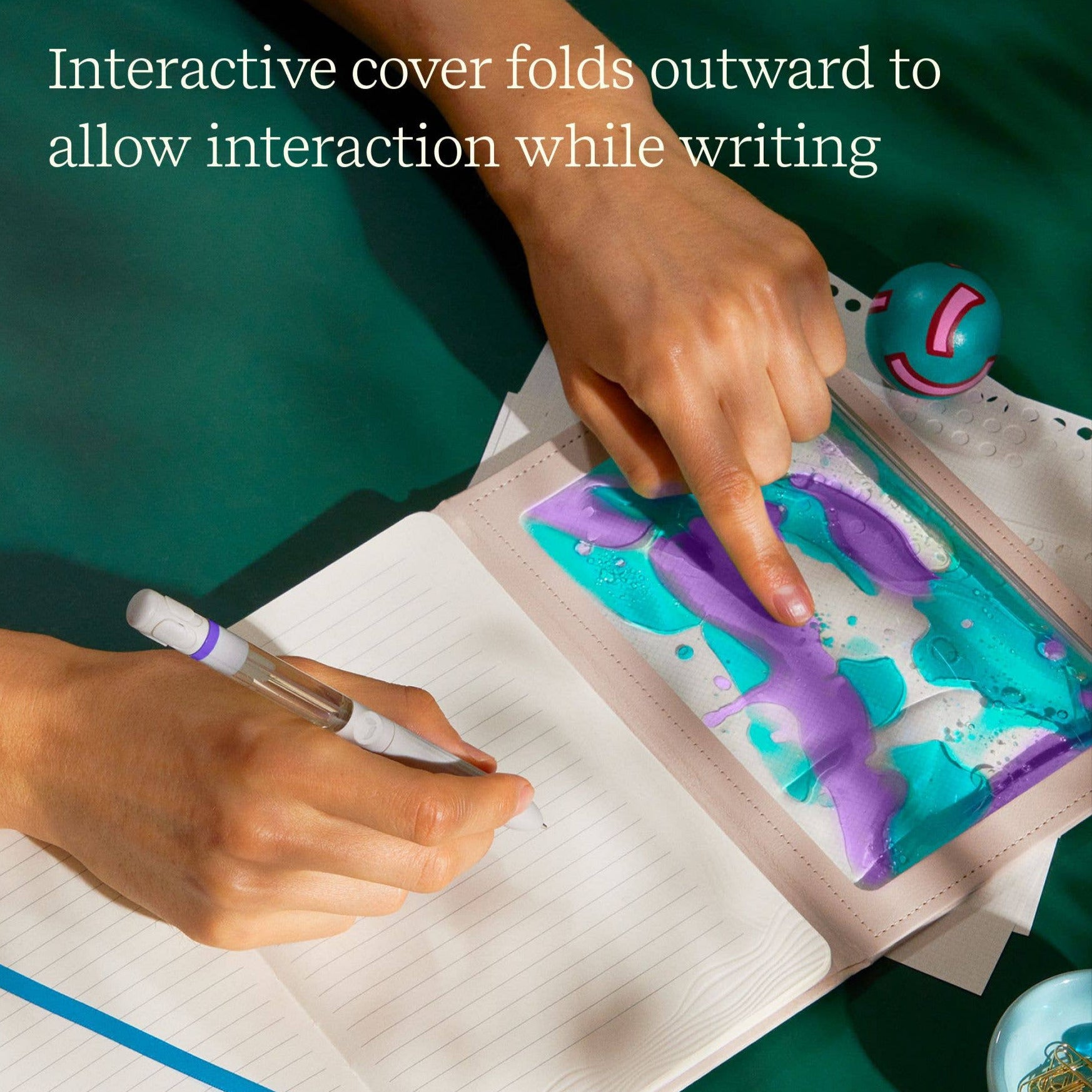 Person interacting with a colorful interactive cover on a notebook