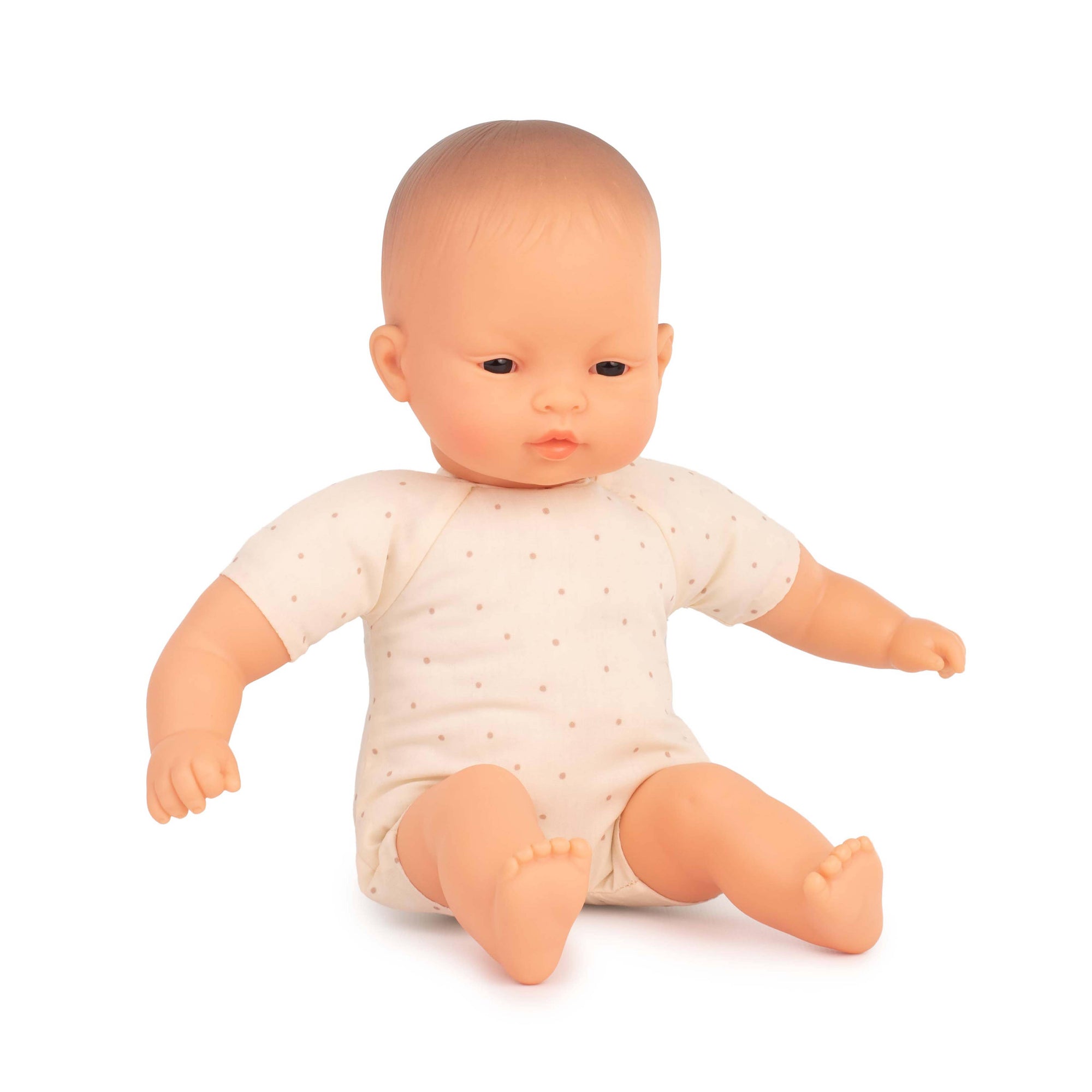 Baby doll wearing a white onesie with small patterns on a white background