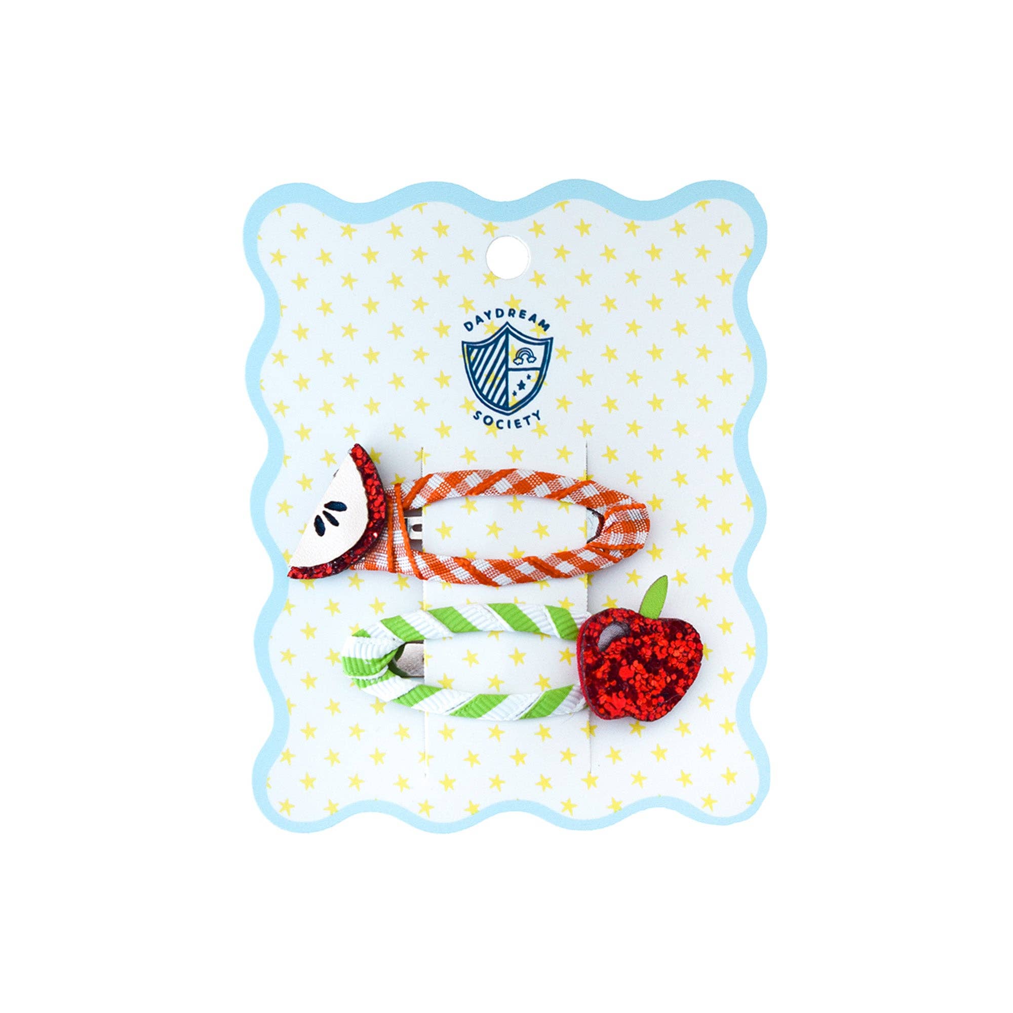 Decorative hair clip with a red heart and orange ribbon on a blue and white polka dot card.