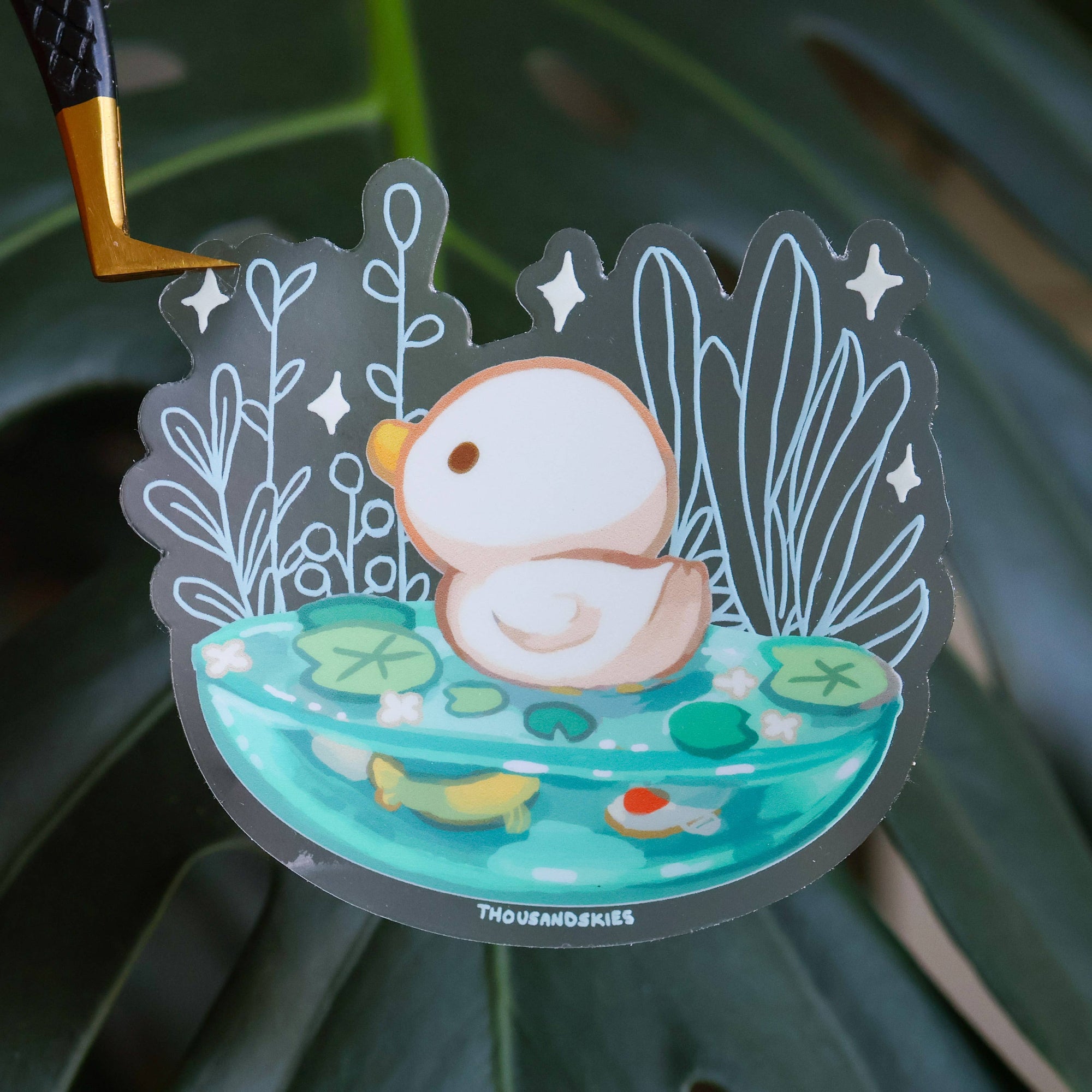 Sticker of a duckling in water with lily pads on a dark green leaf background