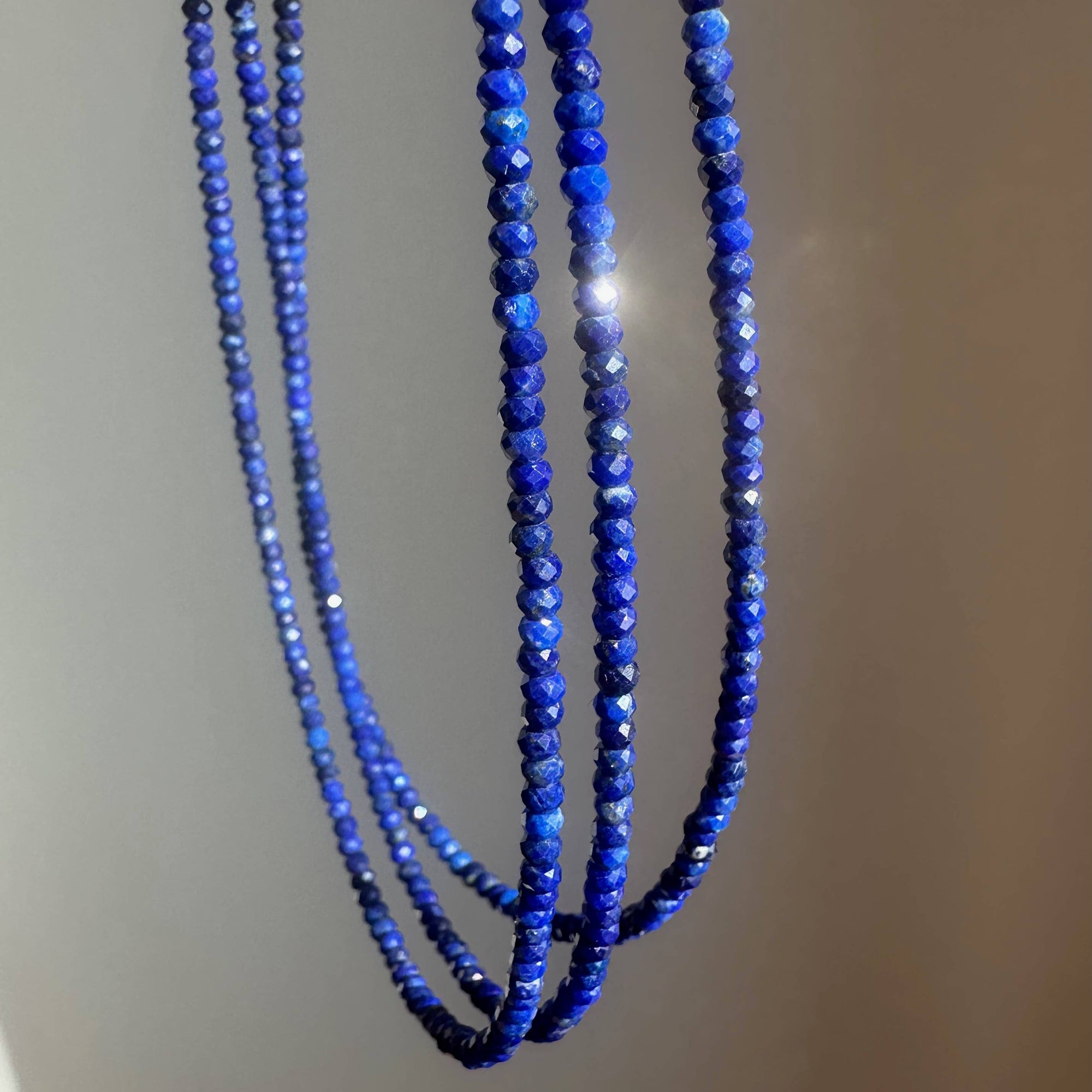Blue beaded necklace on a plain background