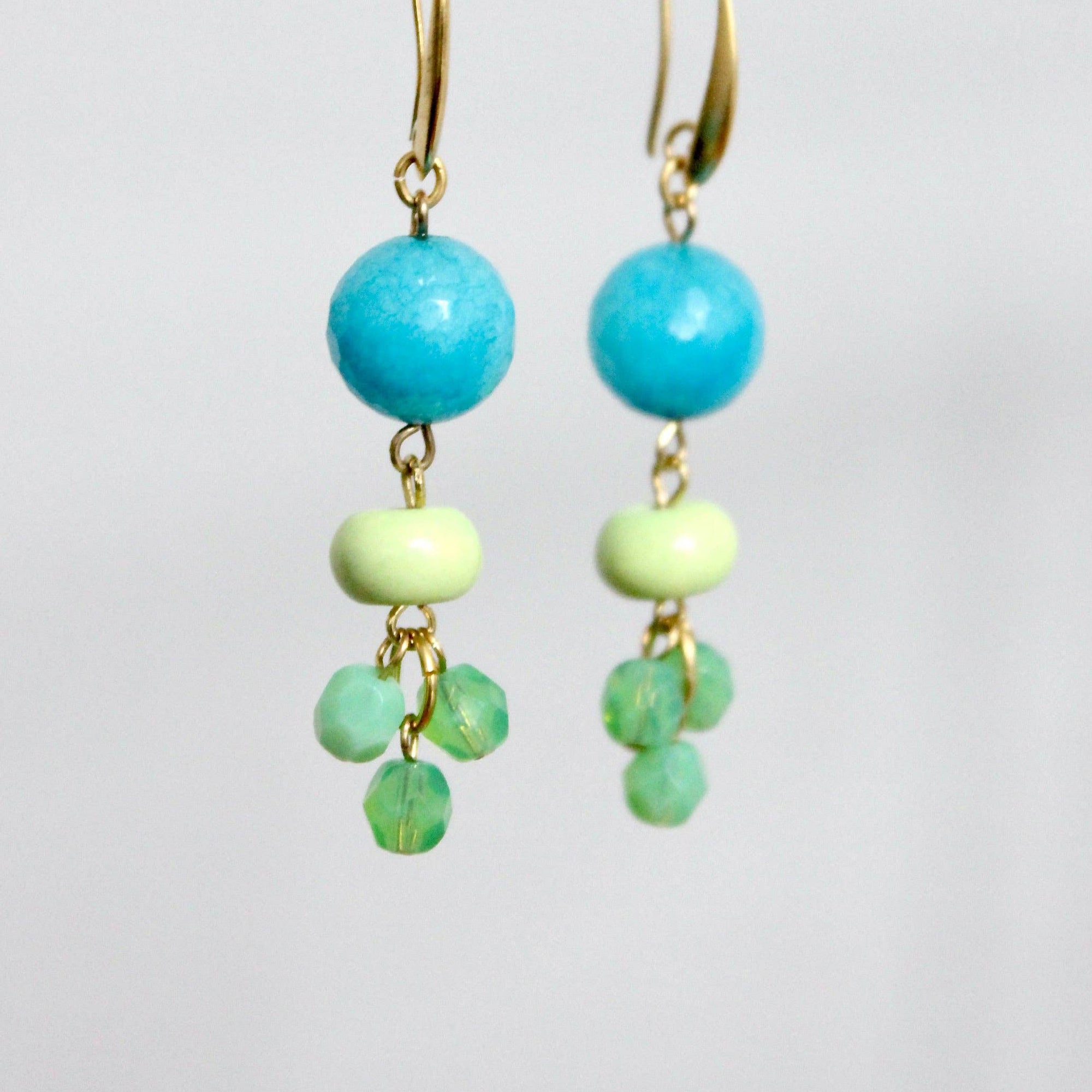 Turquoise and green beaded earrings on a white background