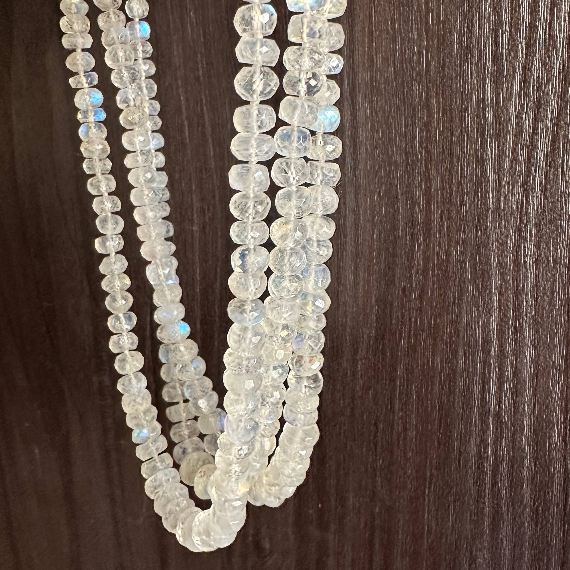 Two strands of clear beads on a wooden surface