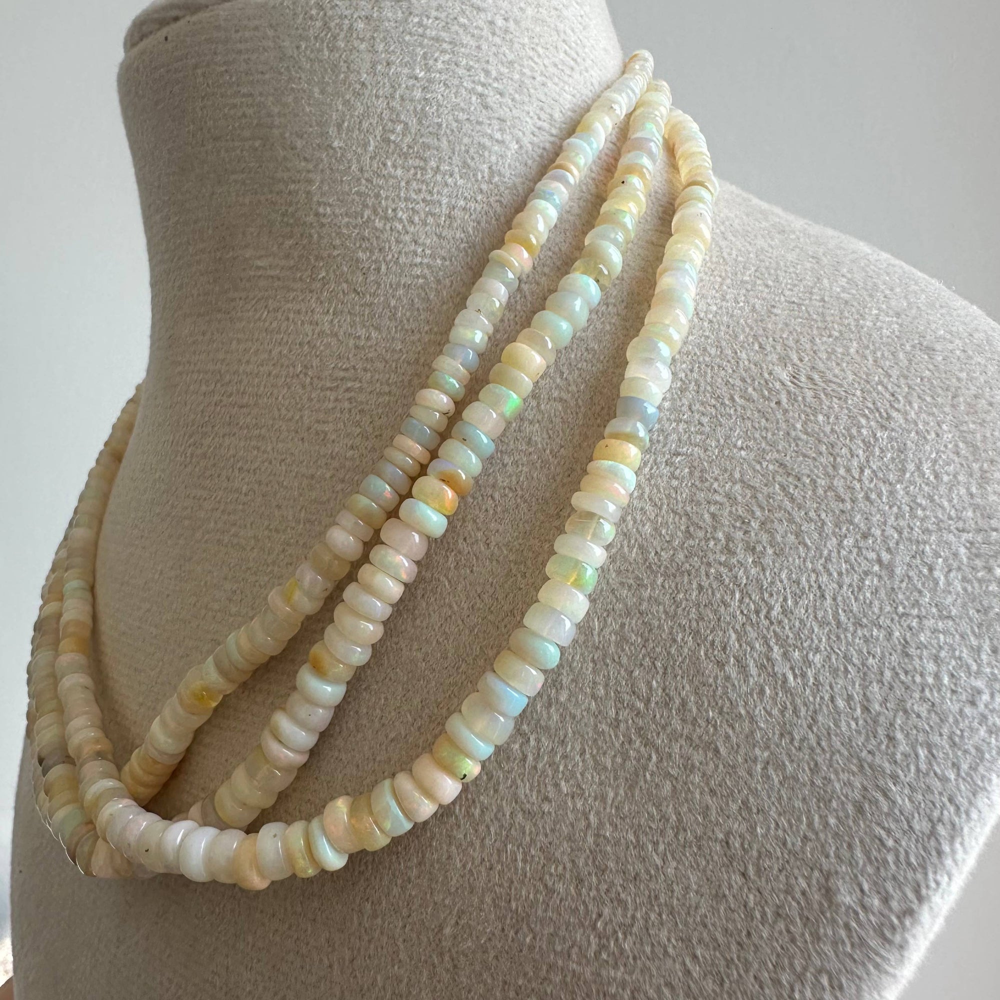 Opal necklace on a mannequin bust against a white background