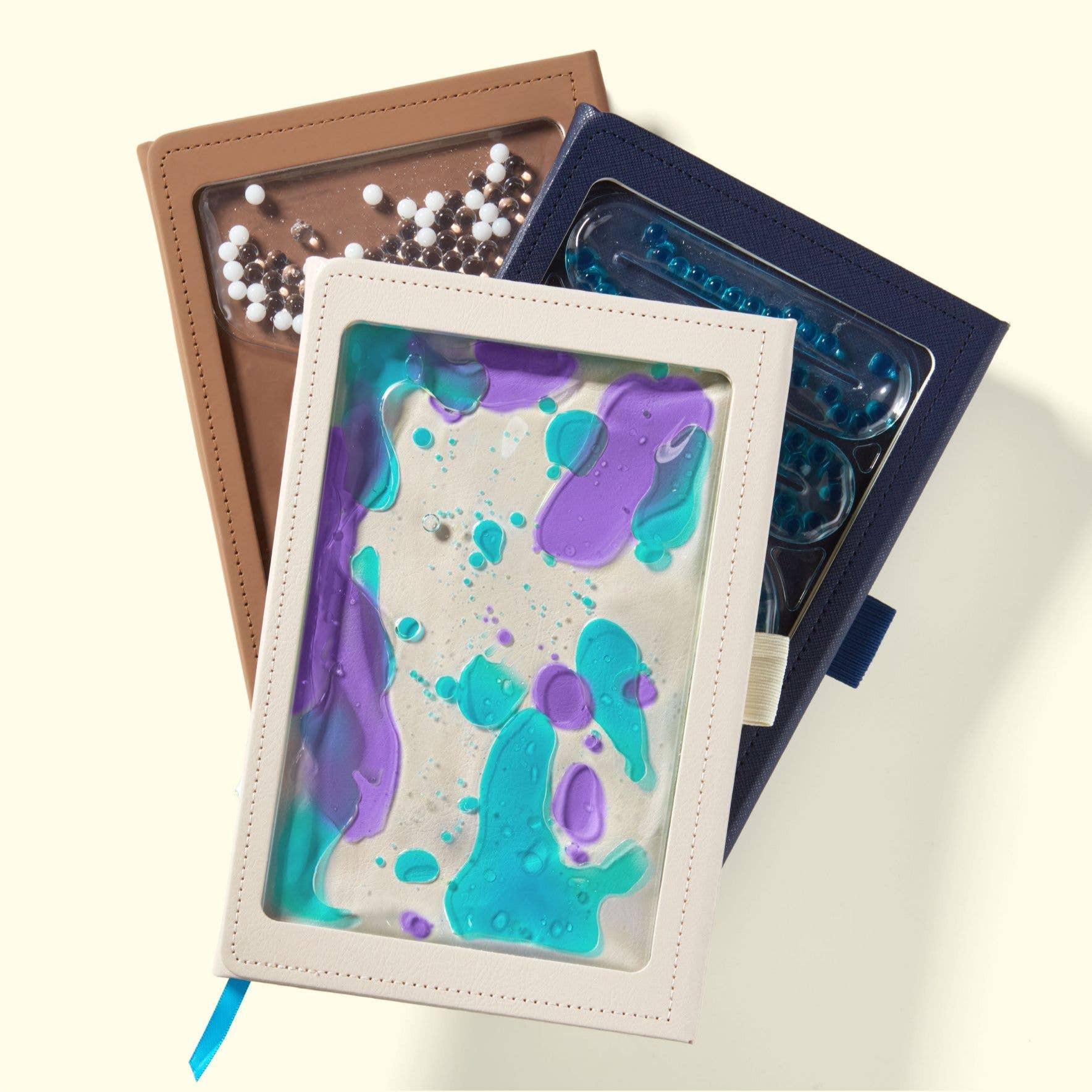 Collection of sensory journals with colorful splatter design on a light background