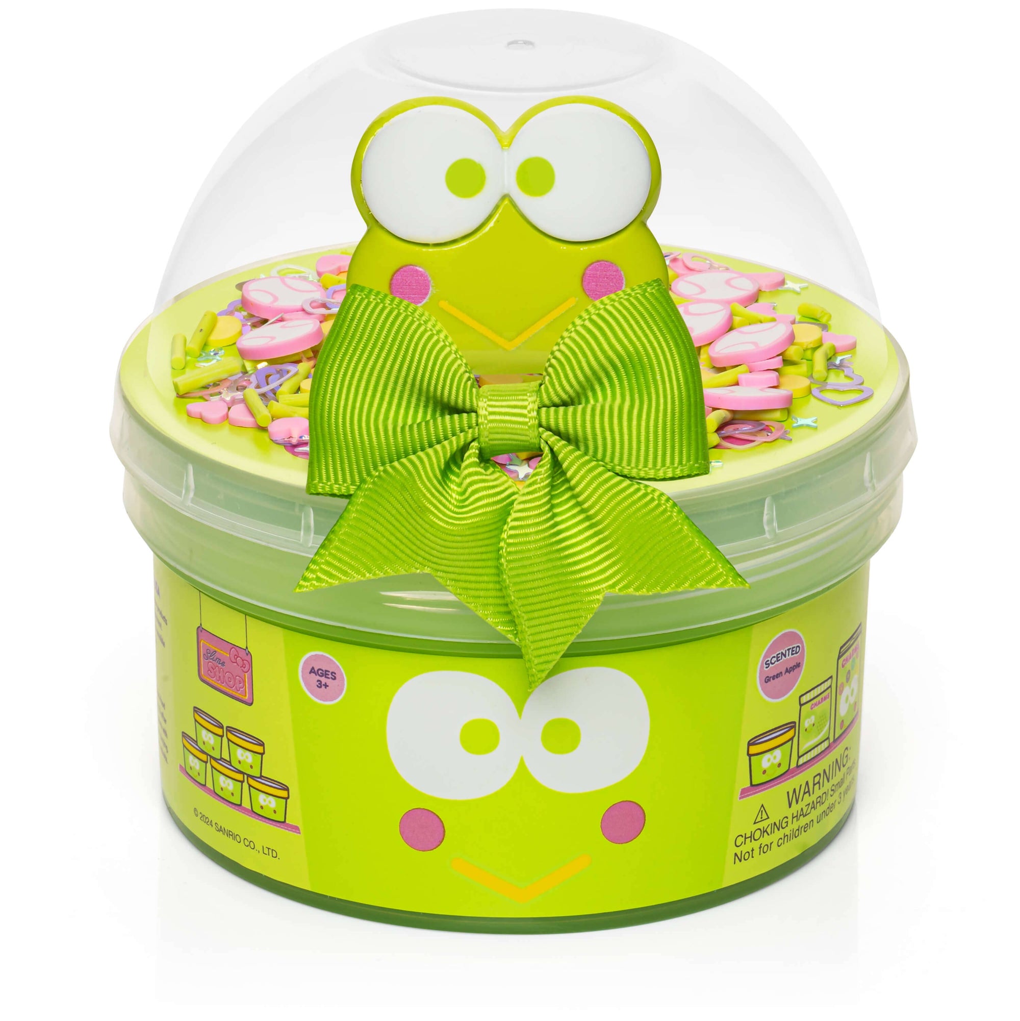 Green container with frog design and bow, filled with small items and slime on a white background