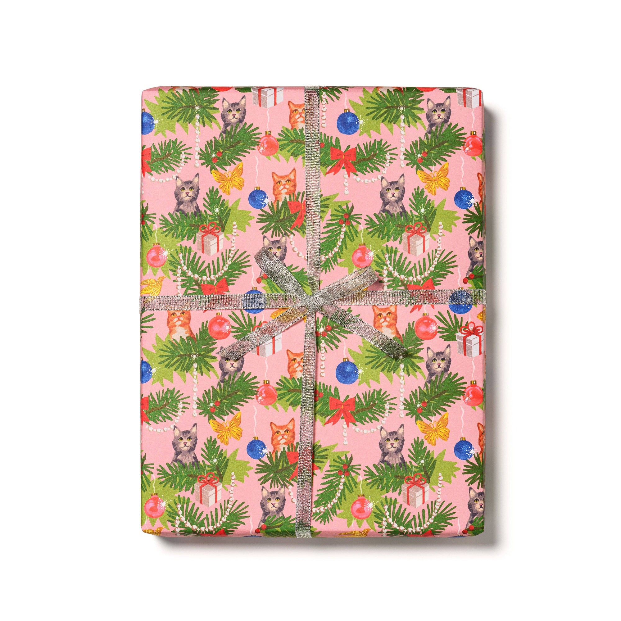 Gift wrap with a festive design featuring cats, trees, and ornaments on a pink background.