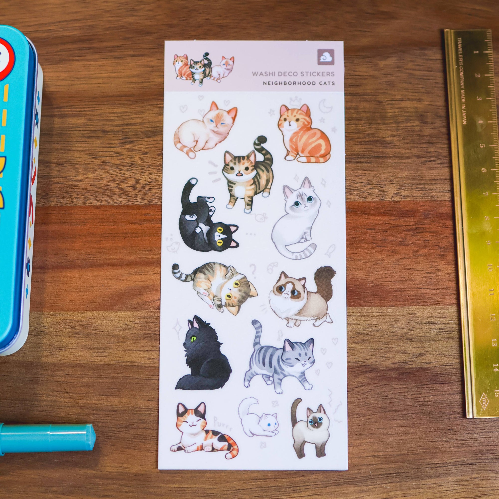 Sheet of cat-themed stickers on a wooden surface with a ruler for scale.