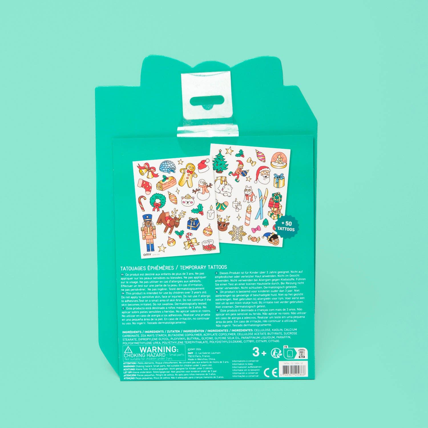 Green packaging of Christmas-themed temporary tattoos on a teal background