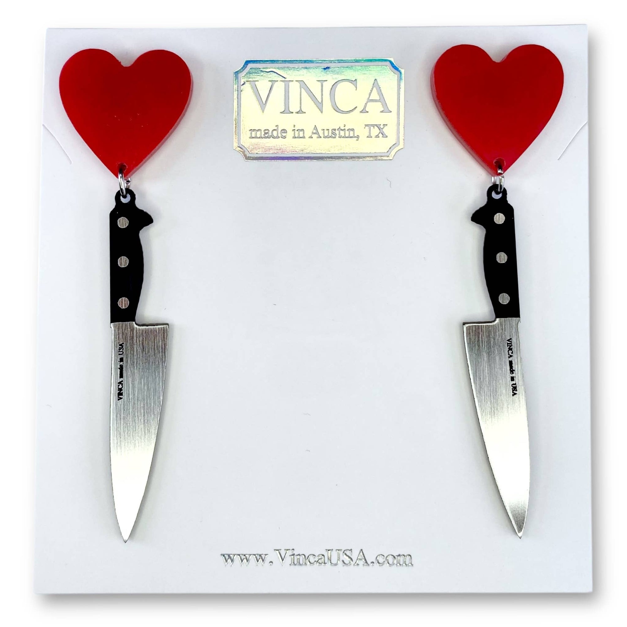 Knife earrings with red heart charms on a white card with 'VINCA' branding.