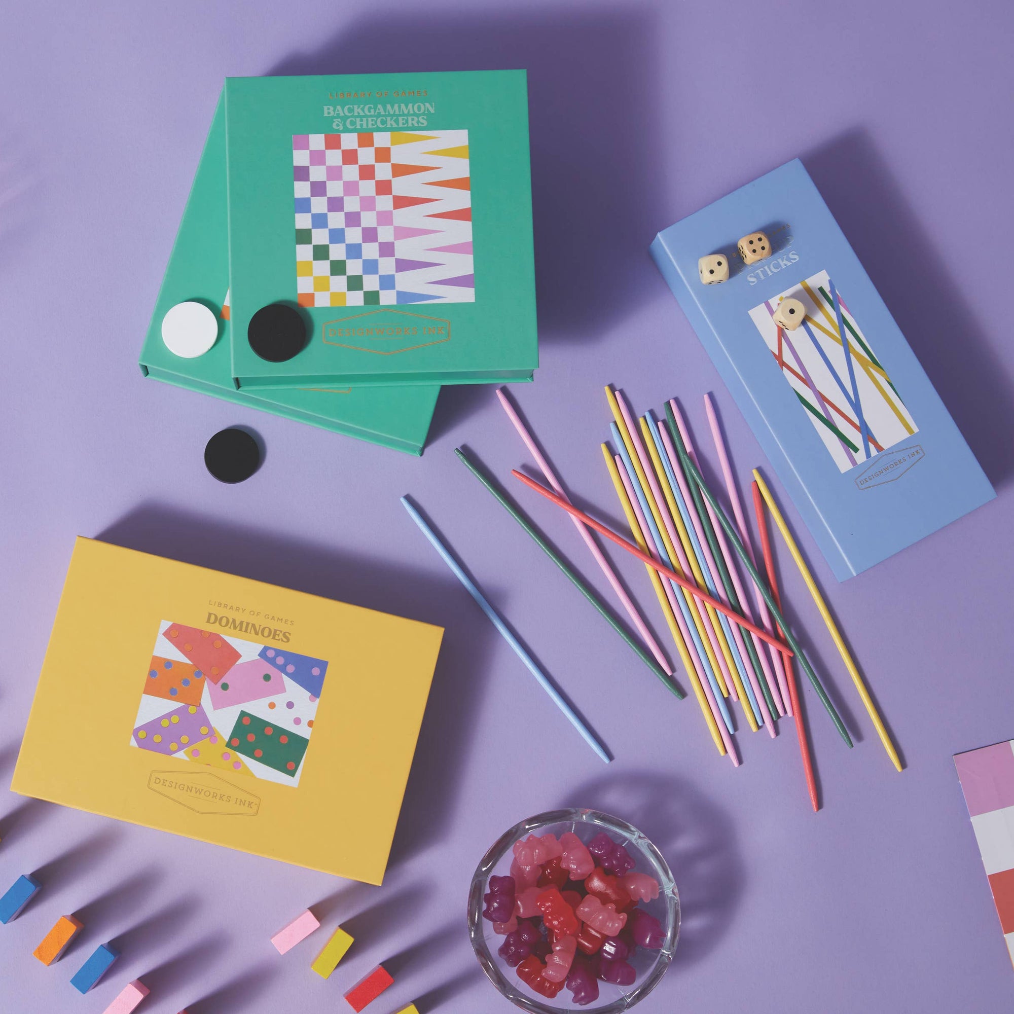 Colorful stationery items including notebooks, pens, and markers on a purple background