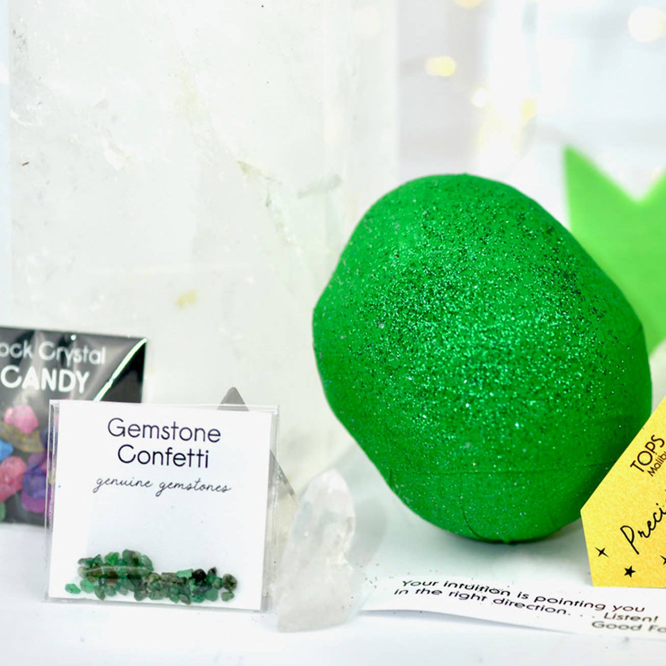 Green gemstone ball with packaging and accessories on a white background