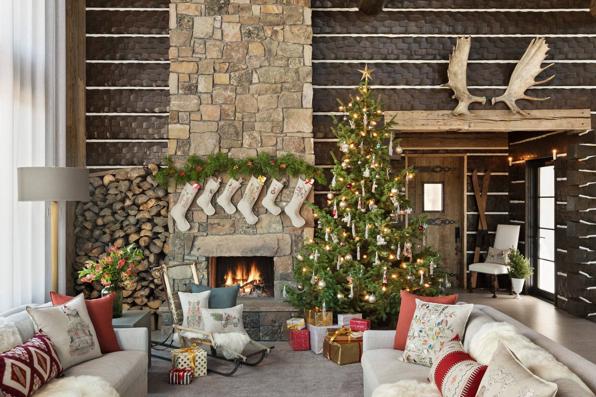 Cozy living room with Christmas decorations, including a tree, stockings, and fireplace.