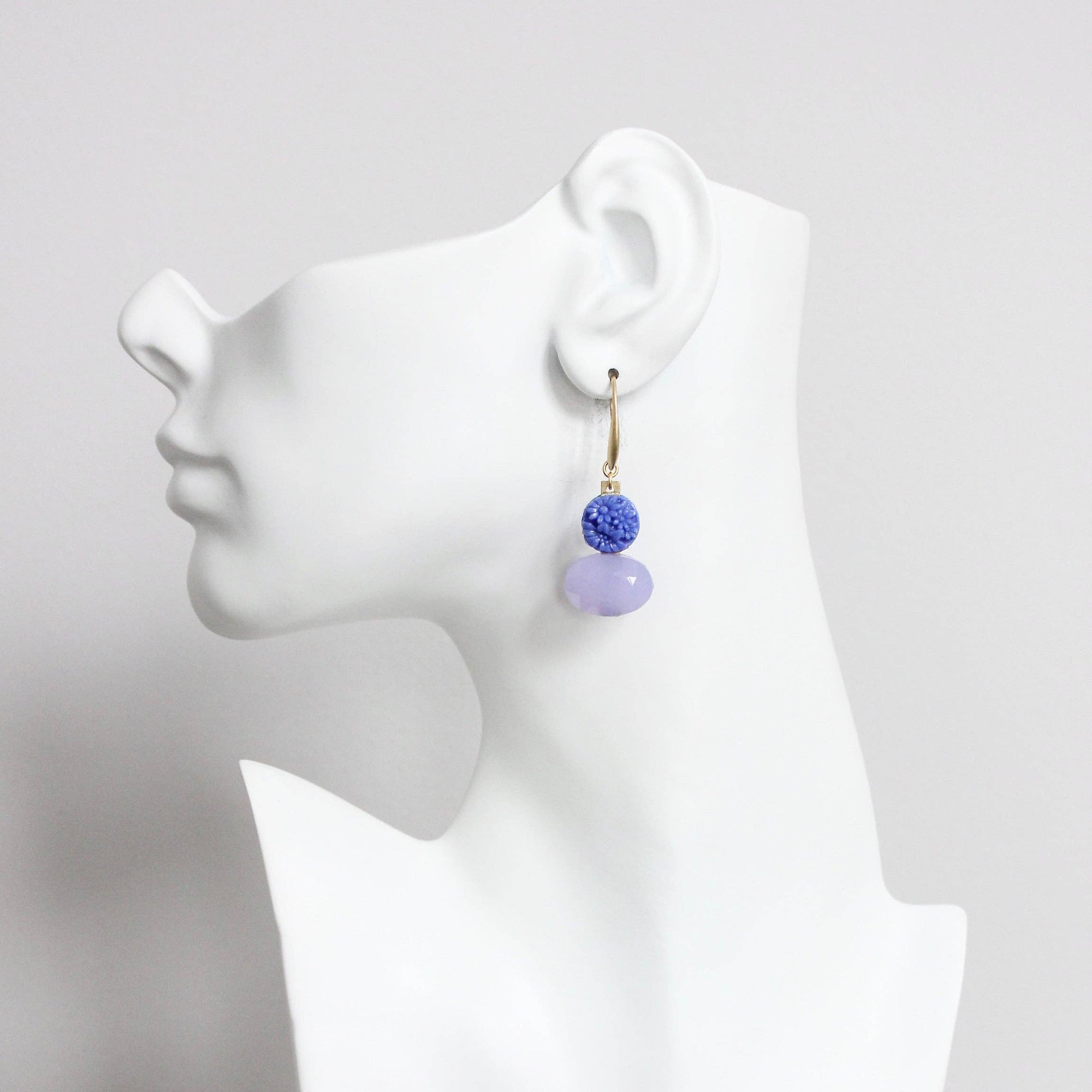 Earring displayed on a mannequin ear with a white background