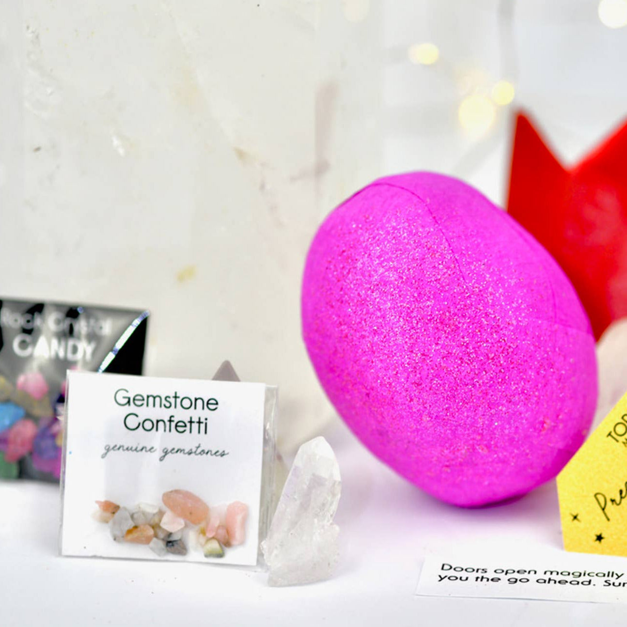 Pink surprise ball with packaging and cards on a light background